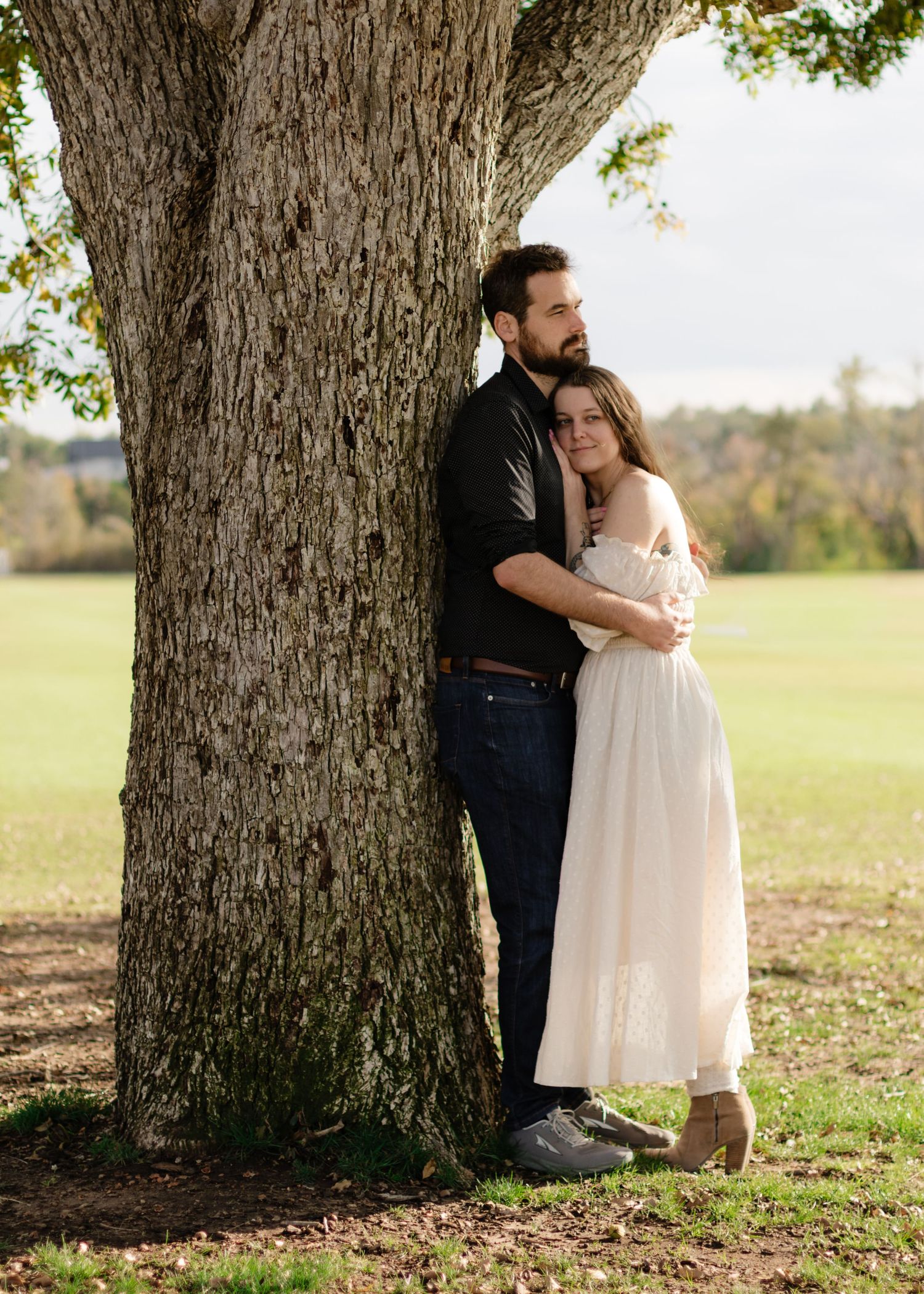A couple holds each other under an old tree at a park near Austin, Texas.