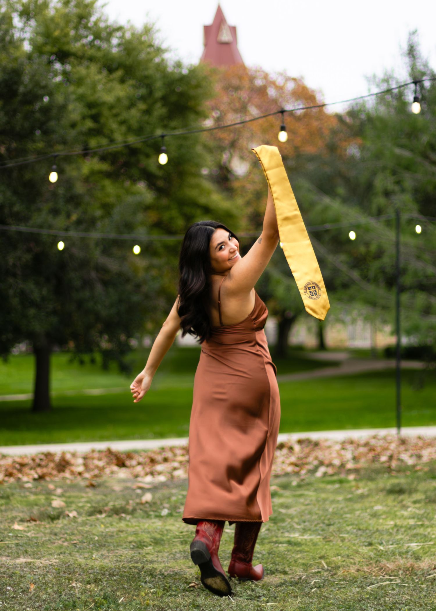 A graduating college senior holds her regalia at St. Edward's University in Austin, Texas, during her senior portraits.