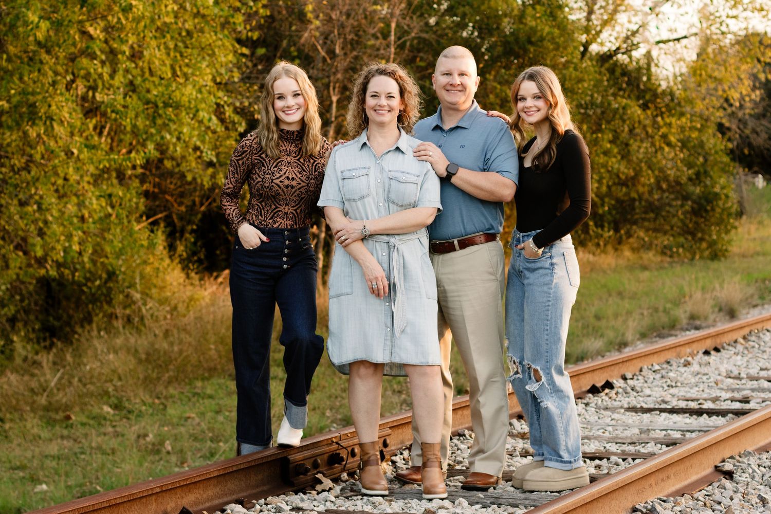 A family of 4 poses on an abandoned railroad track during a photo shoot in Georgetown, Texas.