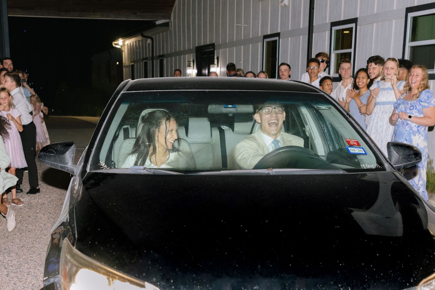 Two newlyweds sit in a car before their wedding send-off in Collinsville, Texas.