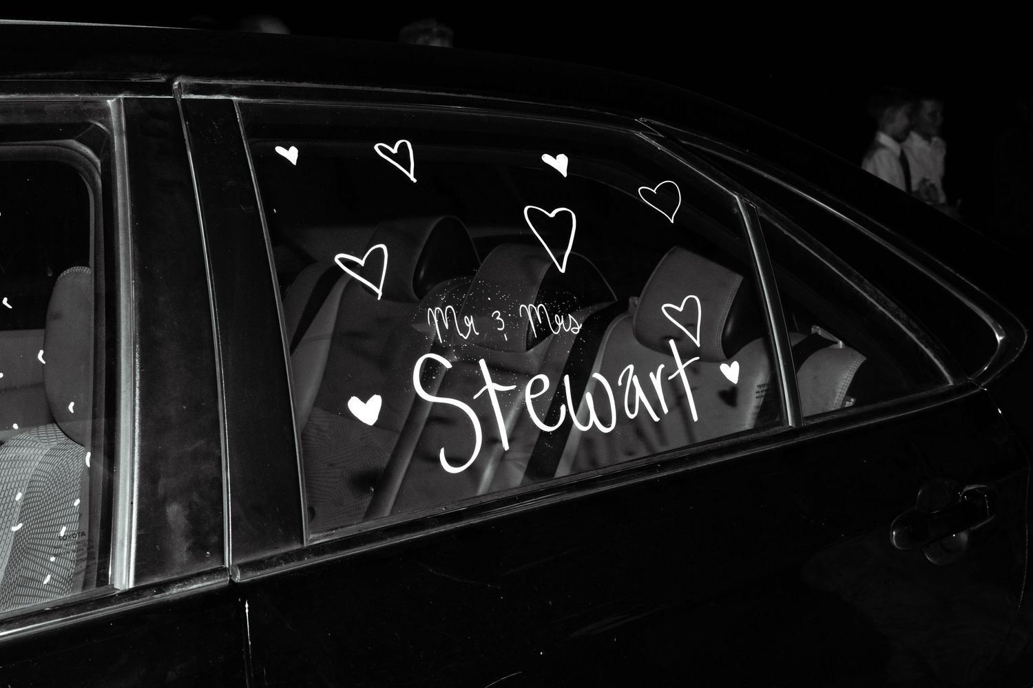 A car window is painted with a newlywed's last name before their wedding send-off near Dallas, Texas.
