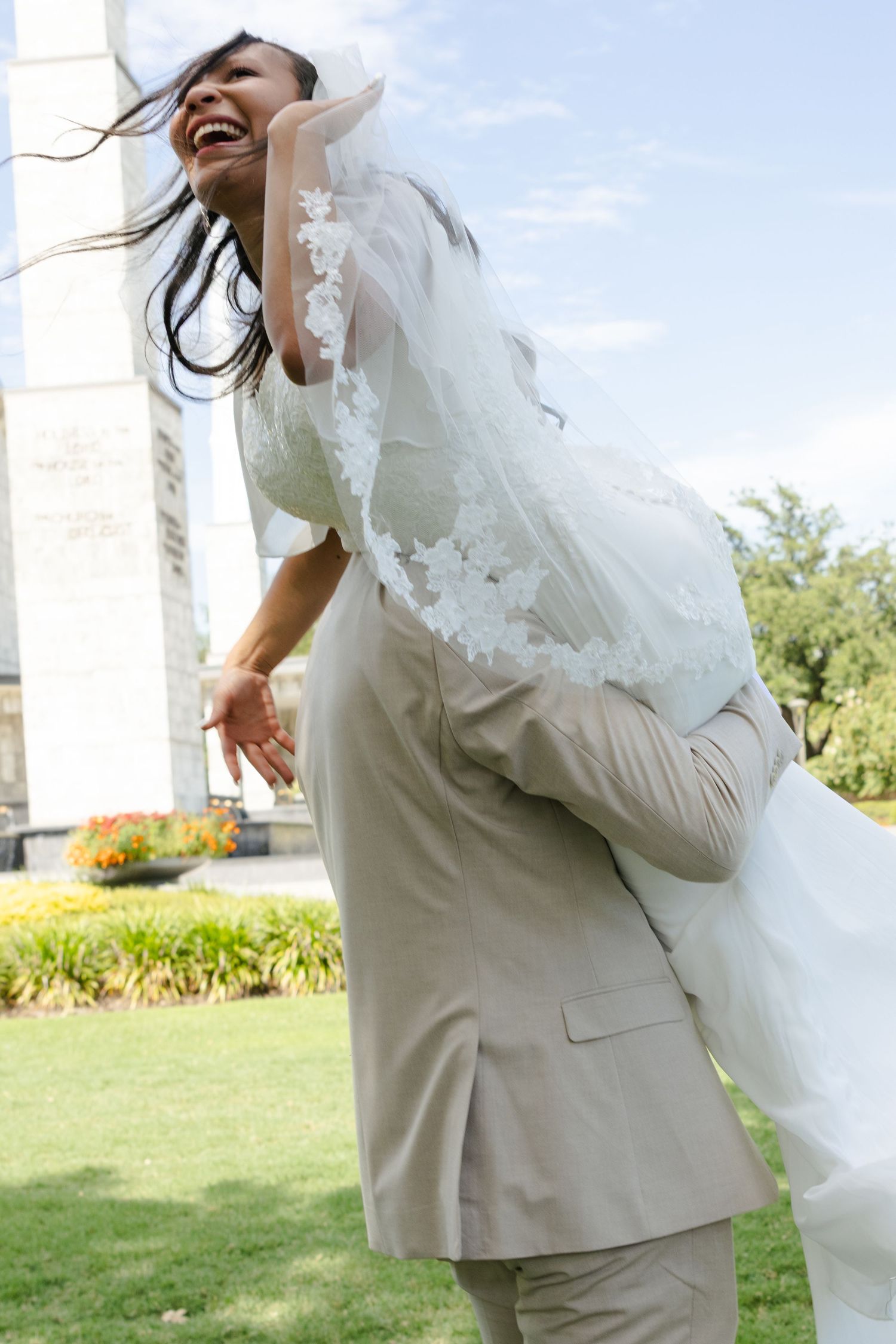 A bride and groom spin around in front of the Latter Day Saints temple in Dallas, Texas.