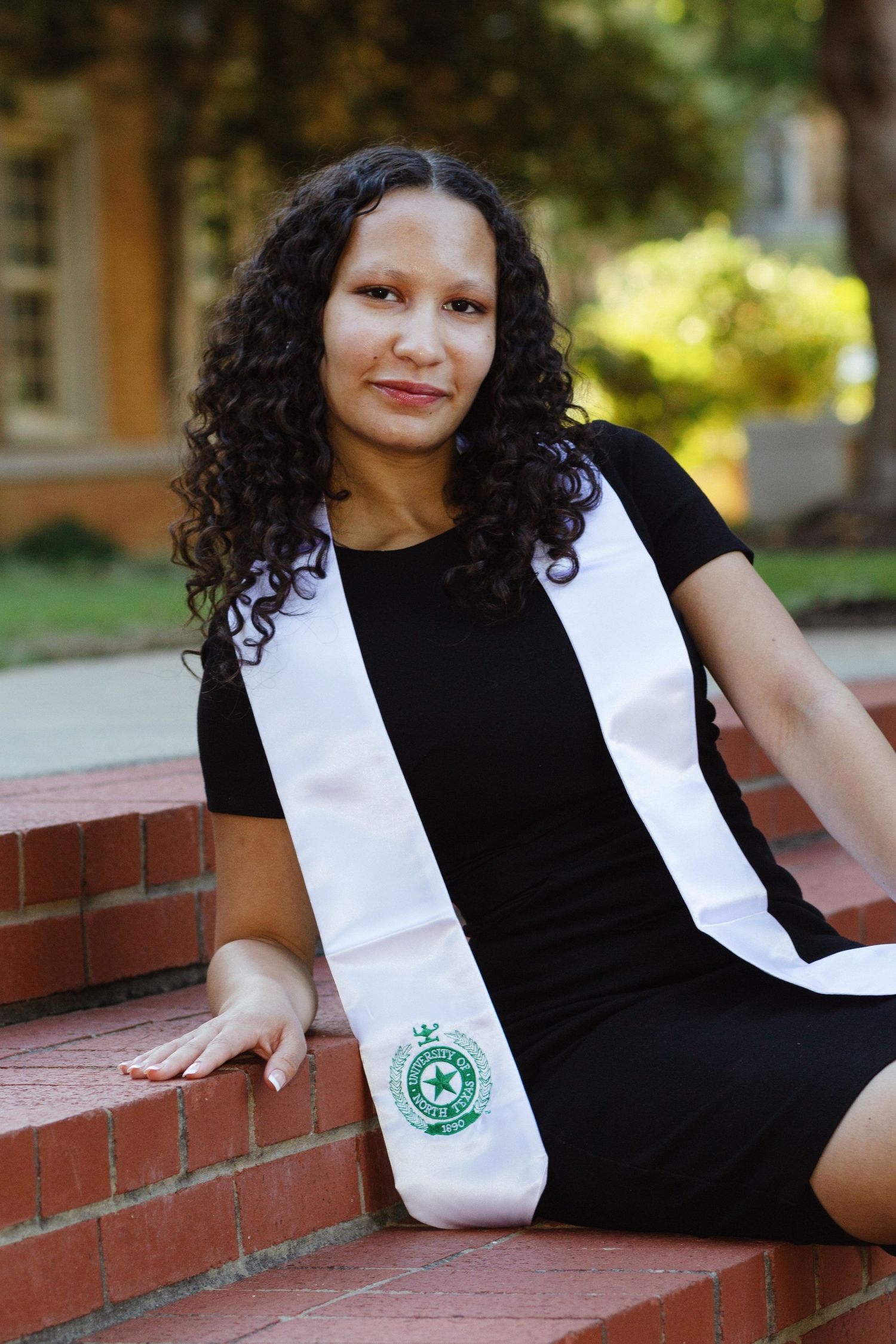 A college student wears her graduation memorabilia on campus.