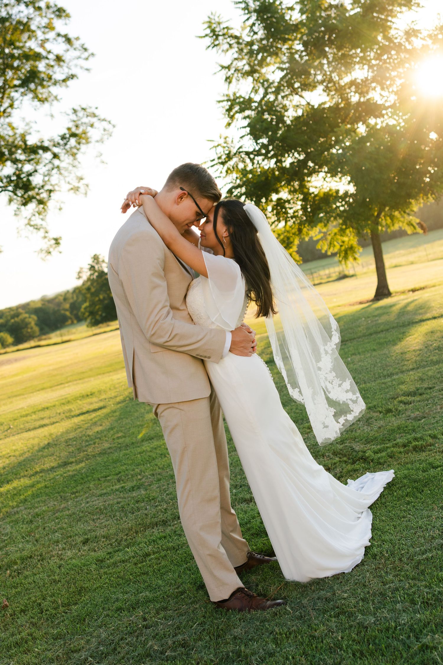 A bride wraps her arms around her groom during sunset at a wedding venue in Collinsville, Texas.