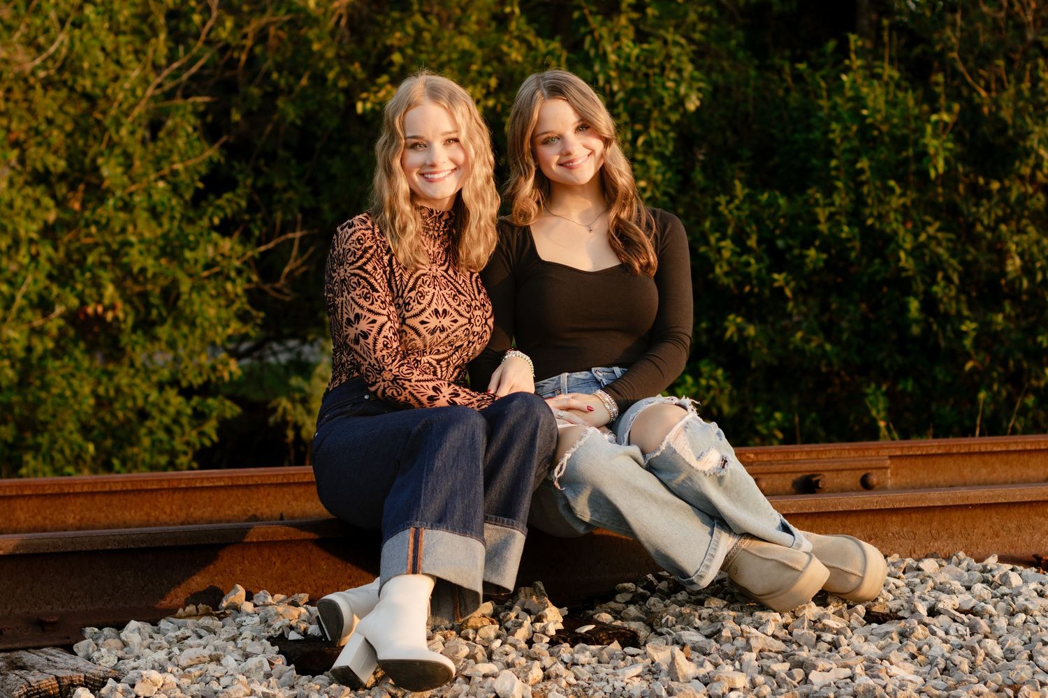 Two sisters pose on an abandoned railroad track during a photo shoot in Georgetown, Texas.