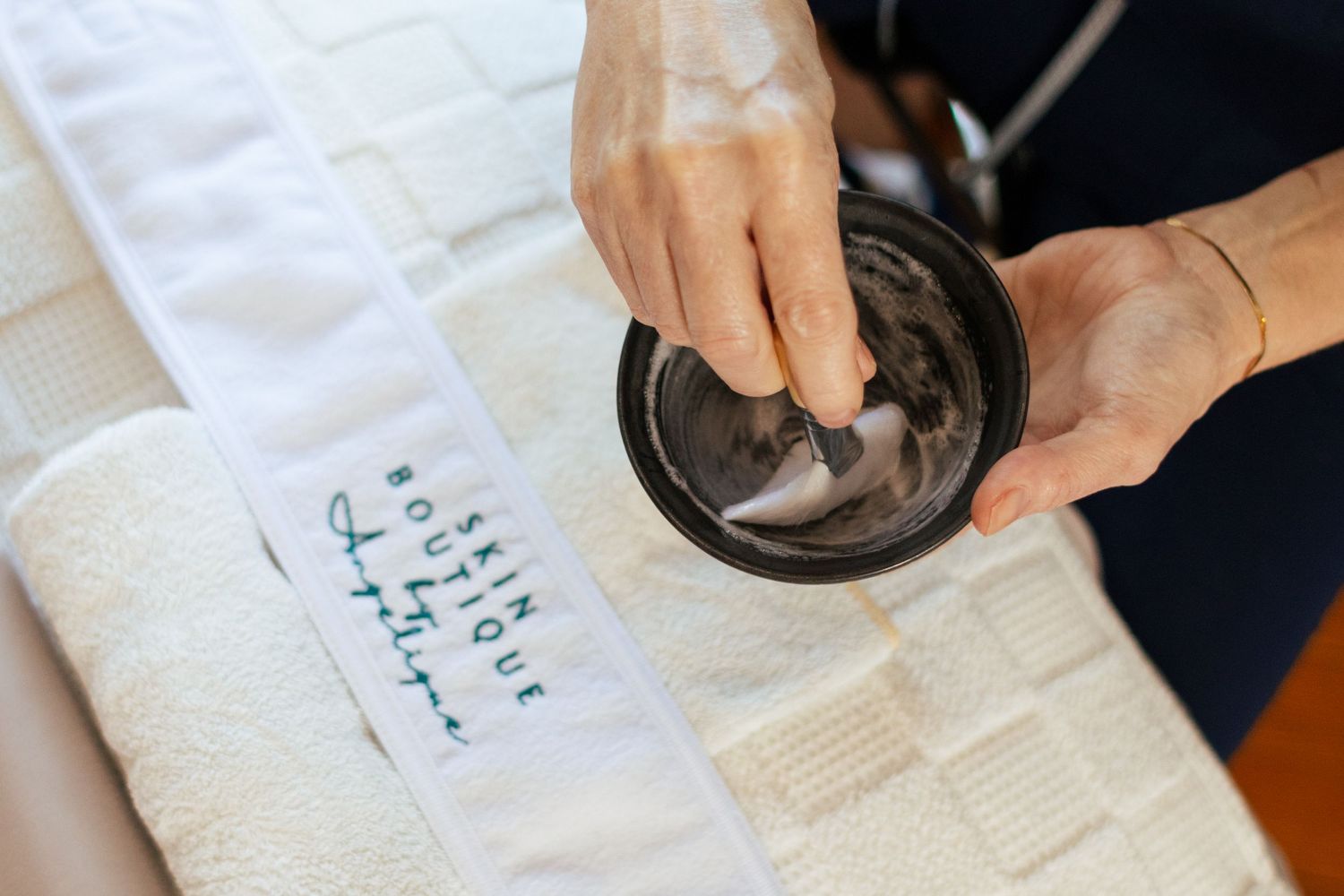 An esthetician holds a skincare product in her boutique salon in Georgetown, Texas.