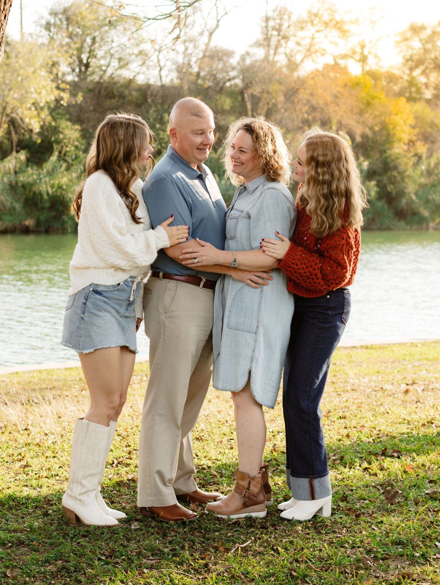 A family hugs each other while smiling and laughing during a photo shoot at San Gabriel Park in Georgetown, Texas.