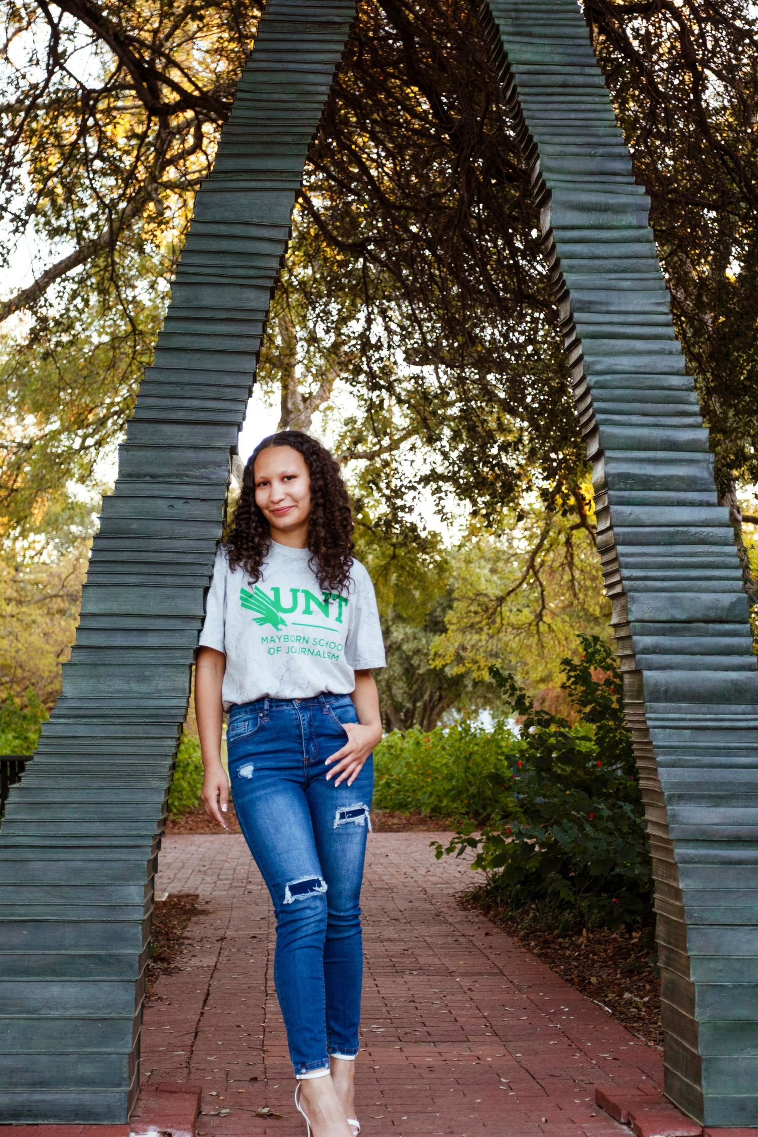 A college student wears her university shirt on campus.