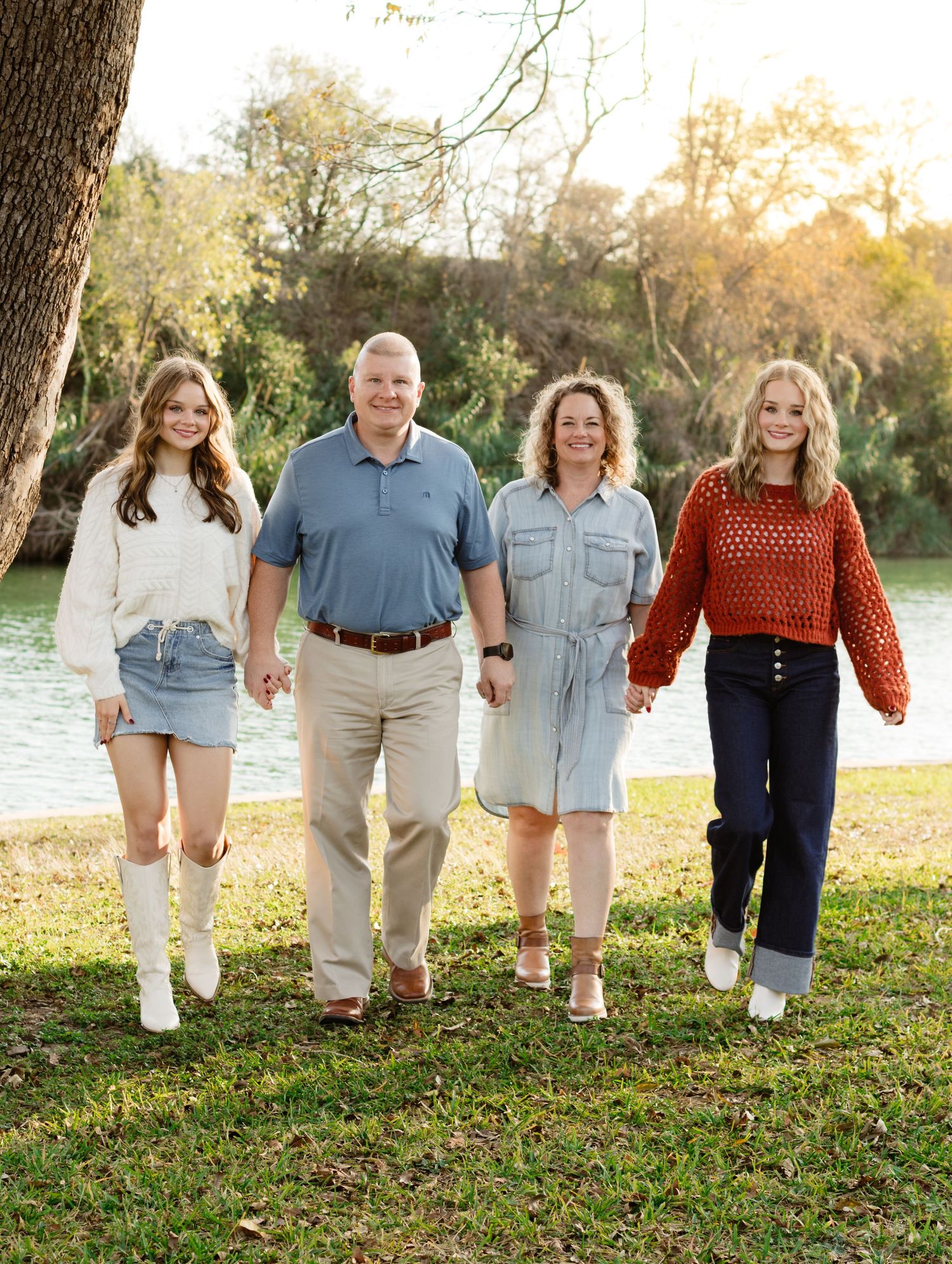 A family walks hand in hand during a photo shoot at San Gabriel Park in Georgetown, Texas.