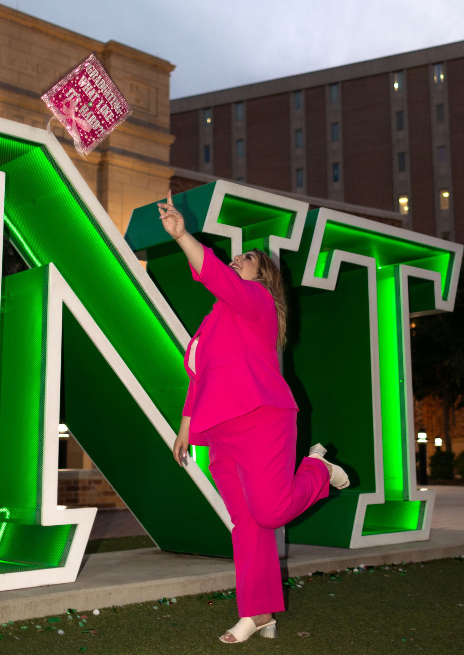 A college student throws her graduation cap in the air.