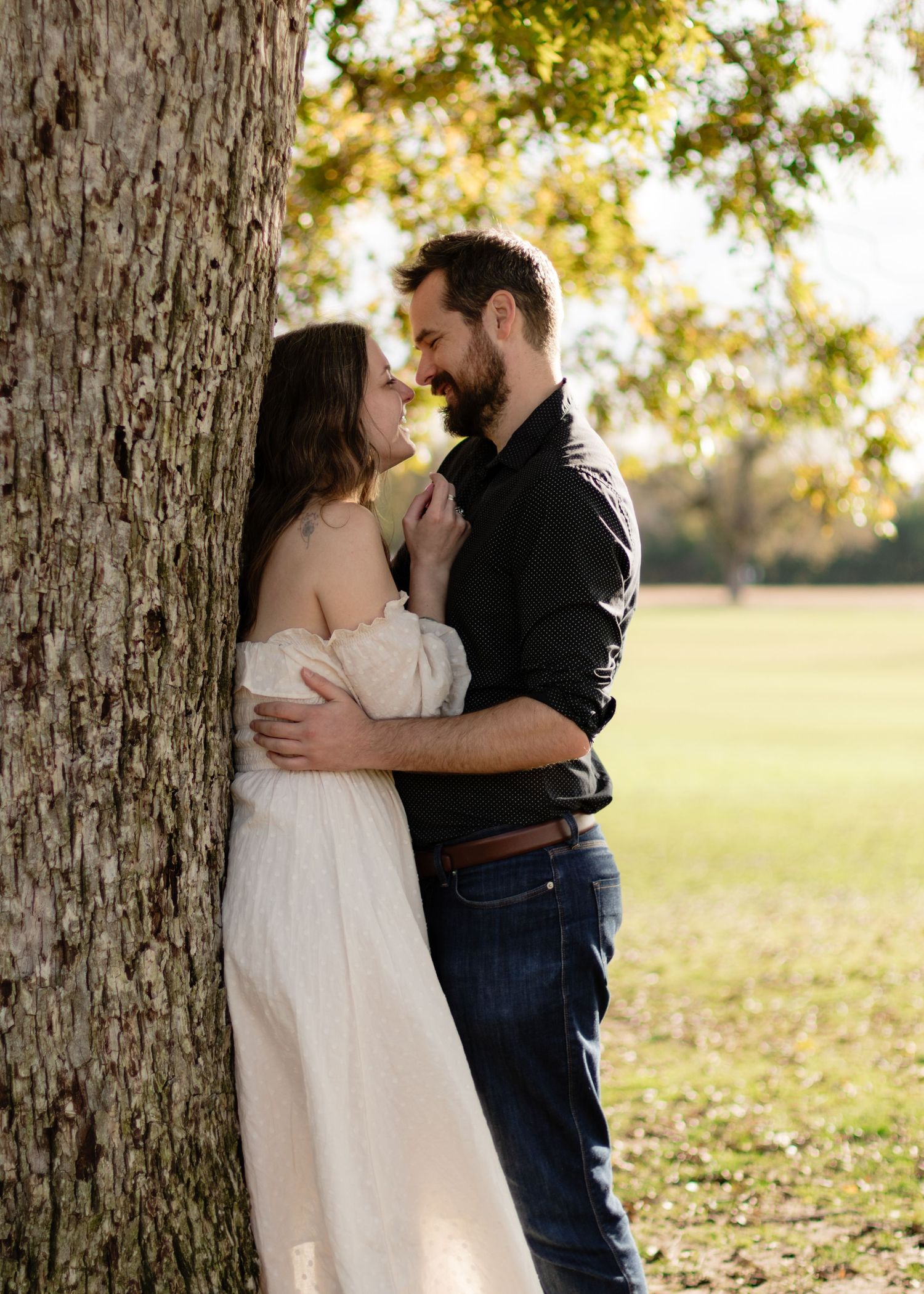 A couple holds each other under an old tree at a park near Austin, Texas.