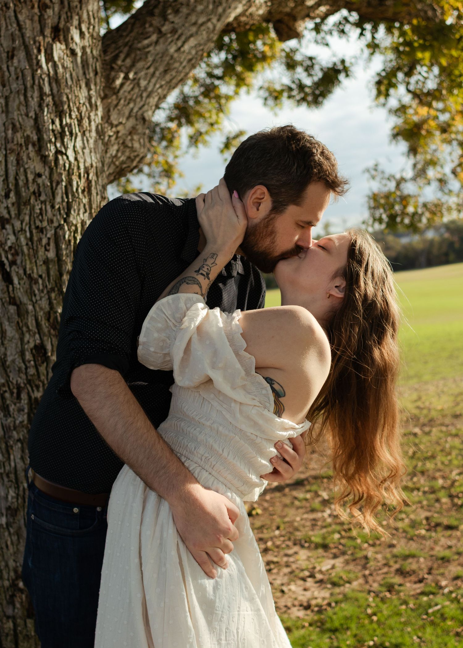 A couple kisses under an old tree near Austin, Texas.