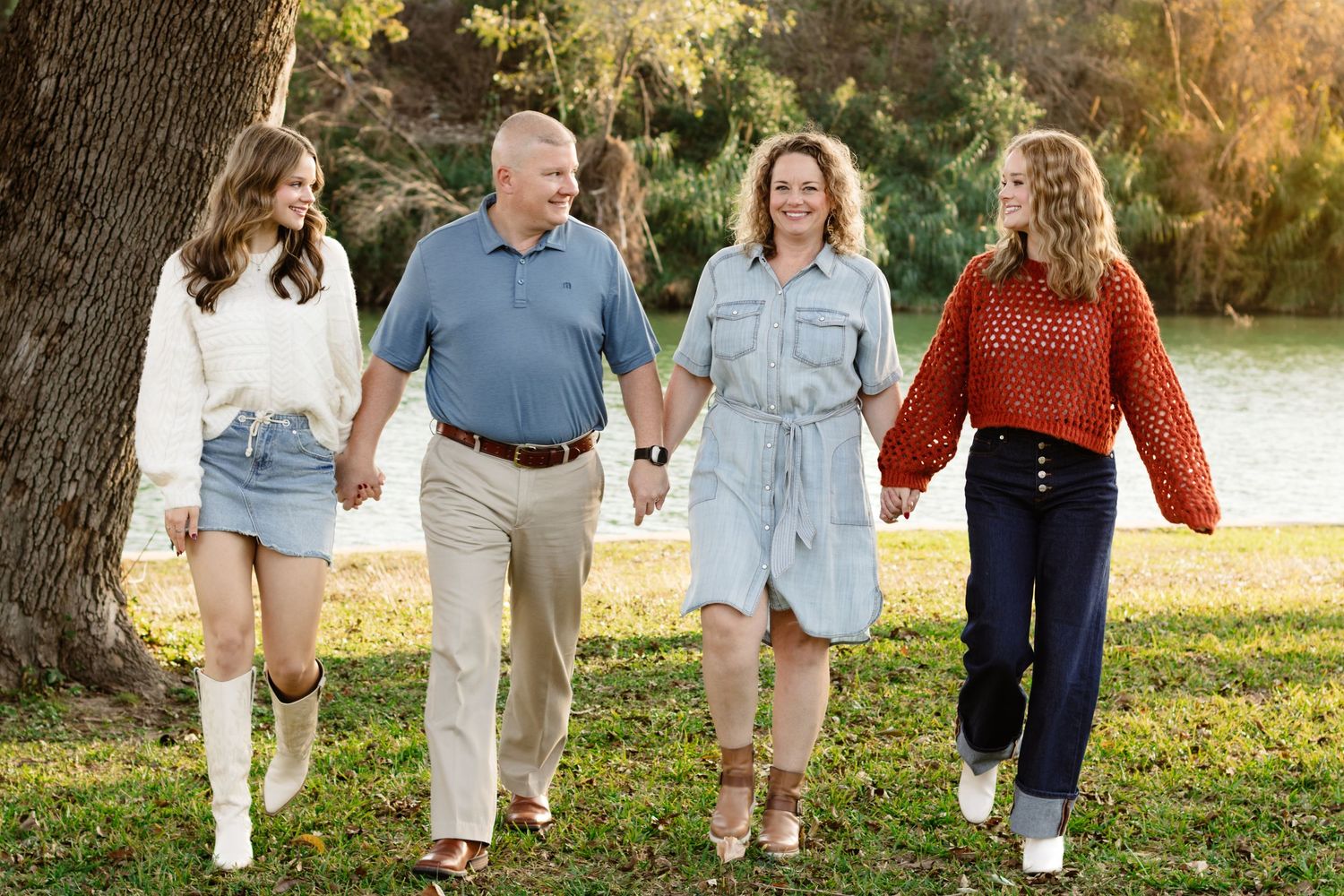 A family walks hand in hand during a photo shoot at San Gabriel Park in Georgetown, Texas.