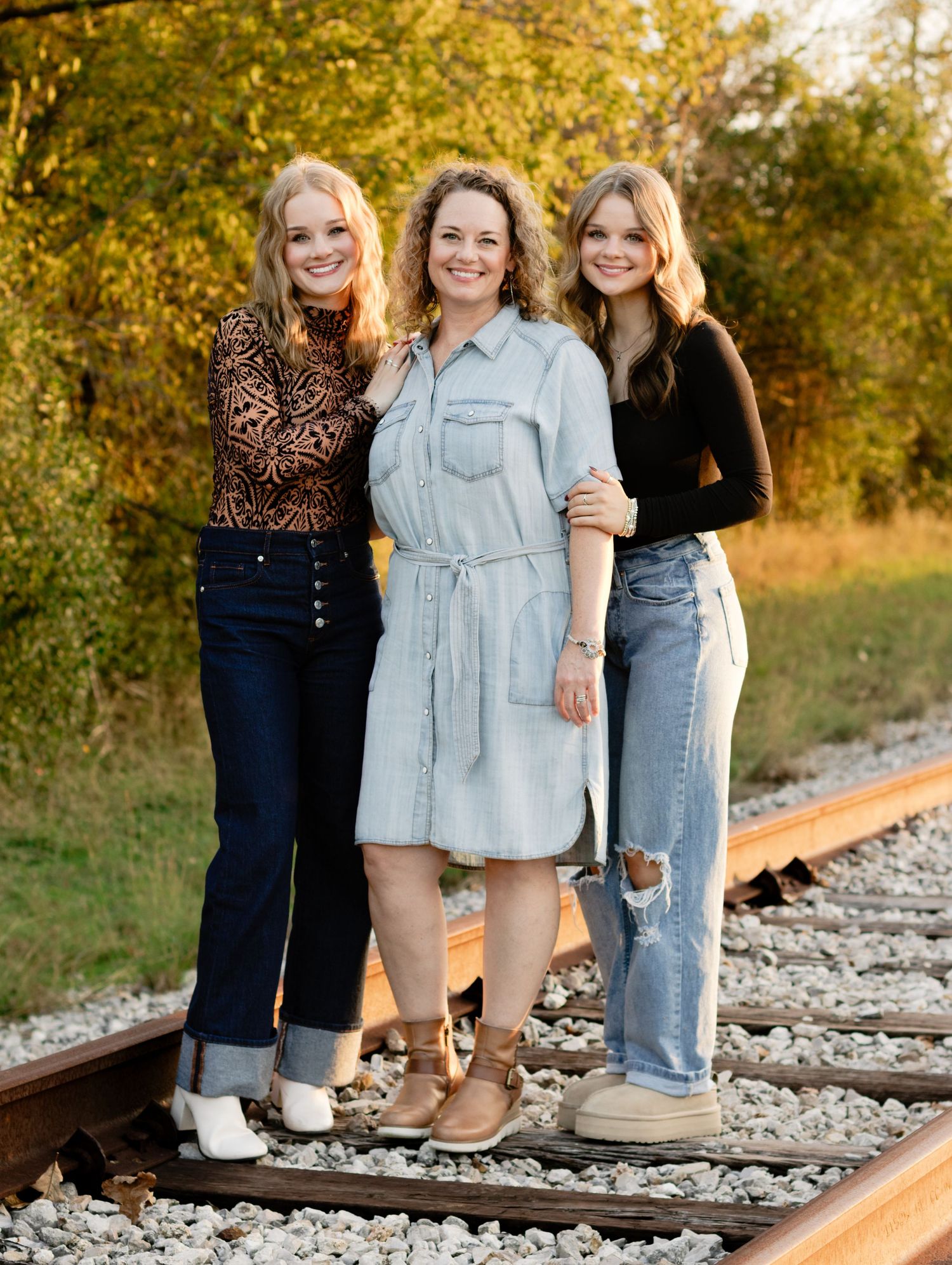 A mom and her daughters pose on an abandoned railroad track during a photo shoot in Georgetown, Texas.