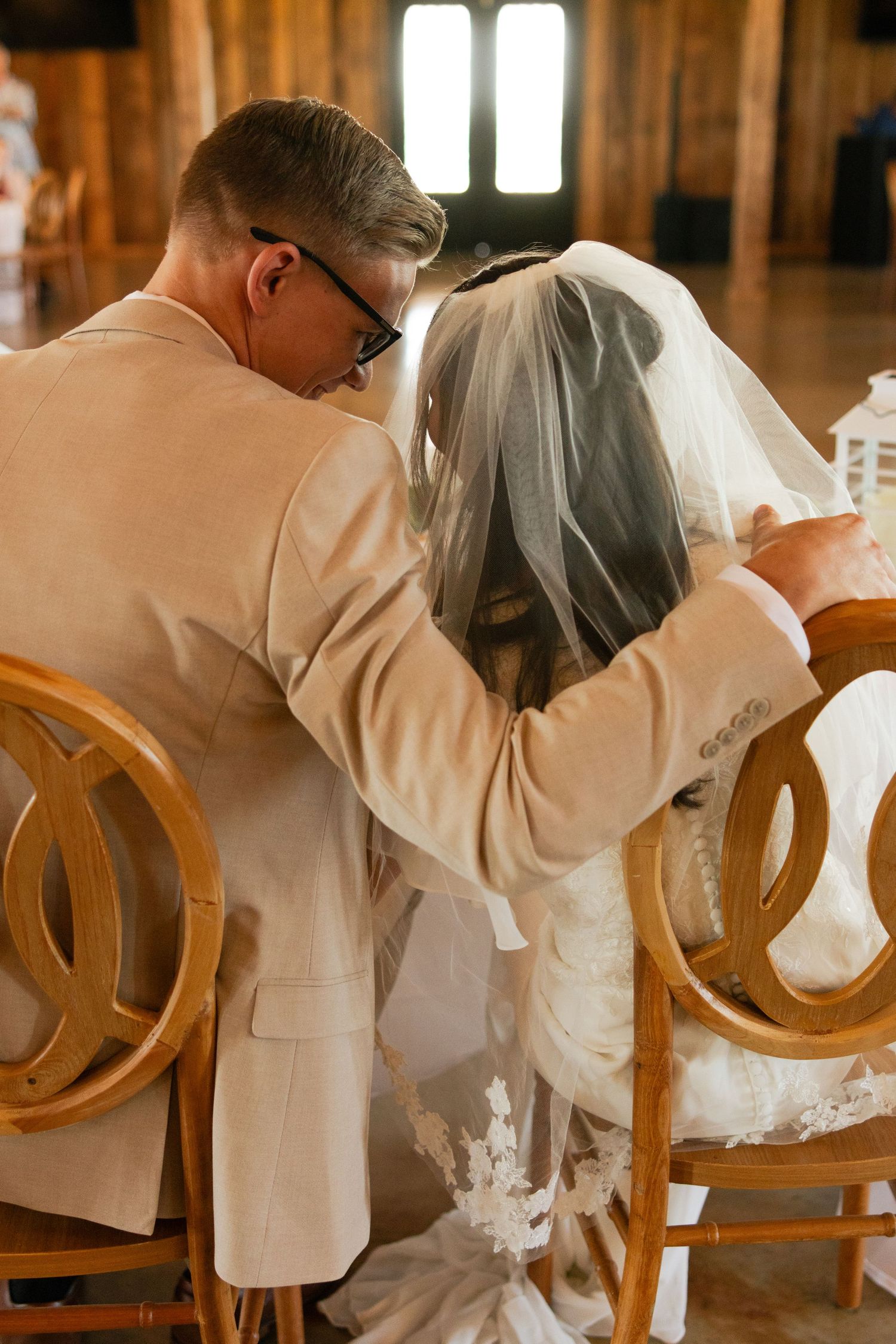 A bride and groom sit at their sweetheart table at their wedding reception in the Texas summer.