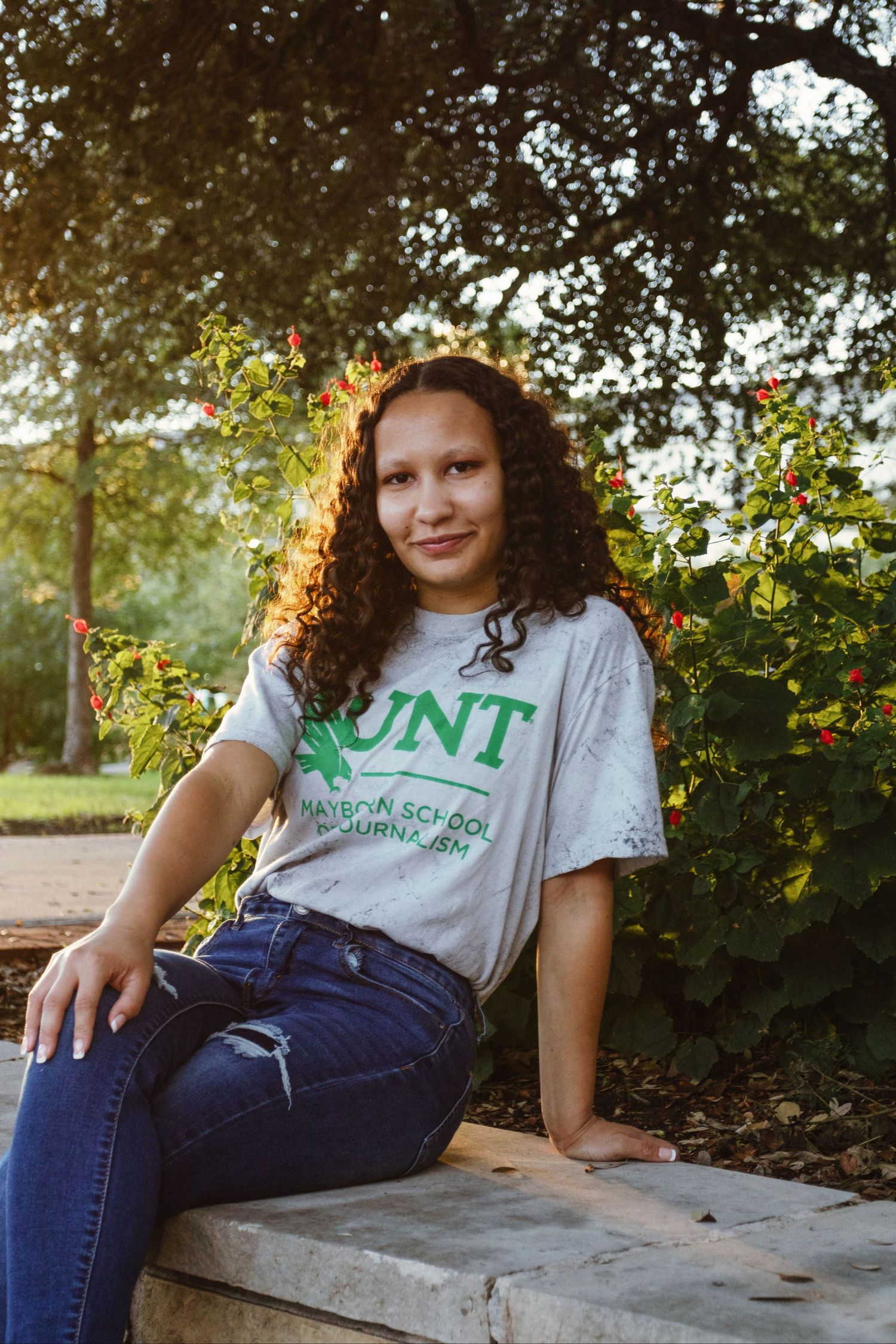 A college student wears her university shirt on campus.