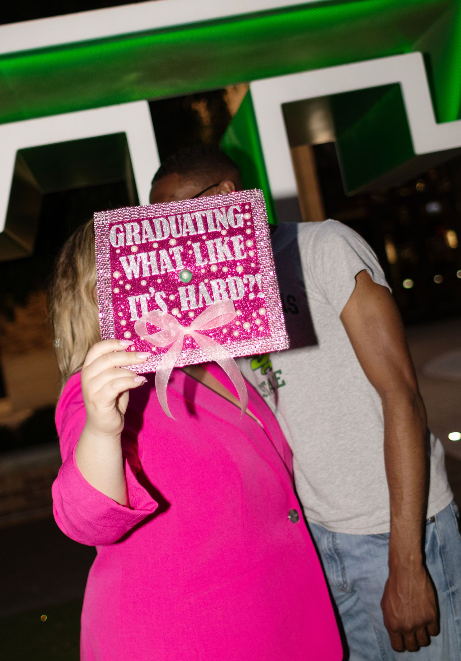 A college student holds her graduation cap on campus.