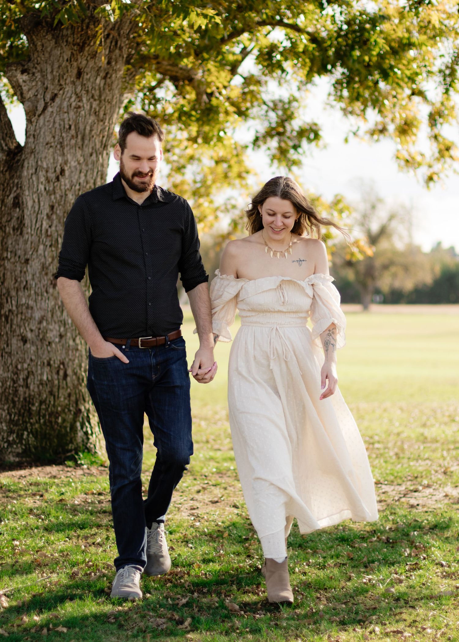 A couple walks through a park near an old tree at a park near Austin, Texas.