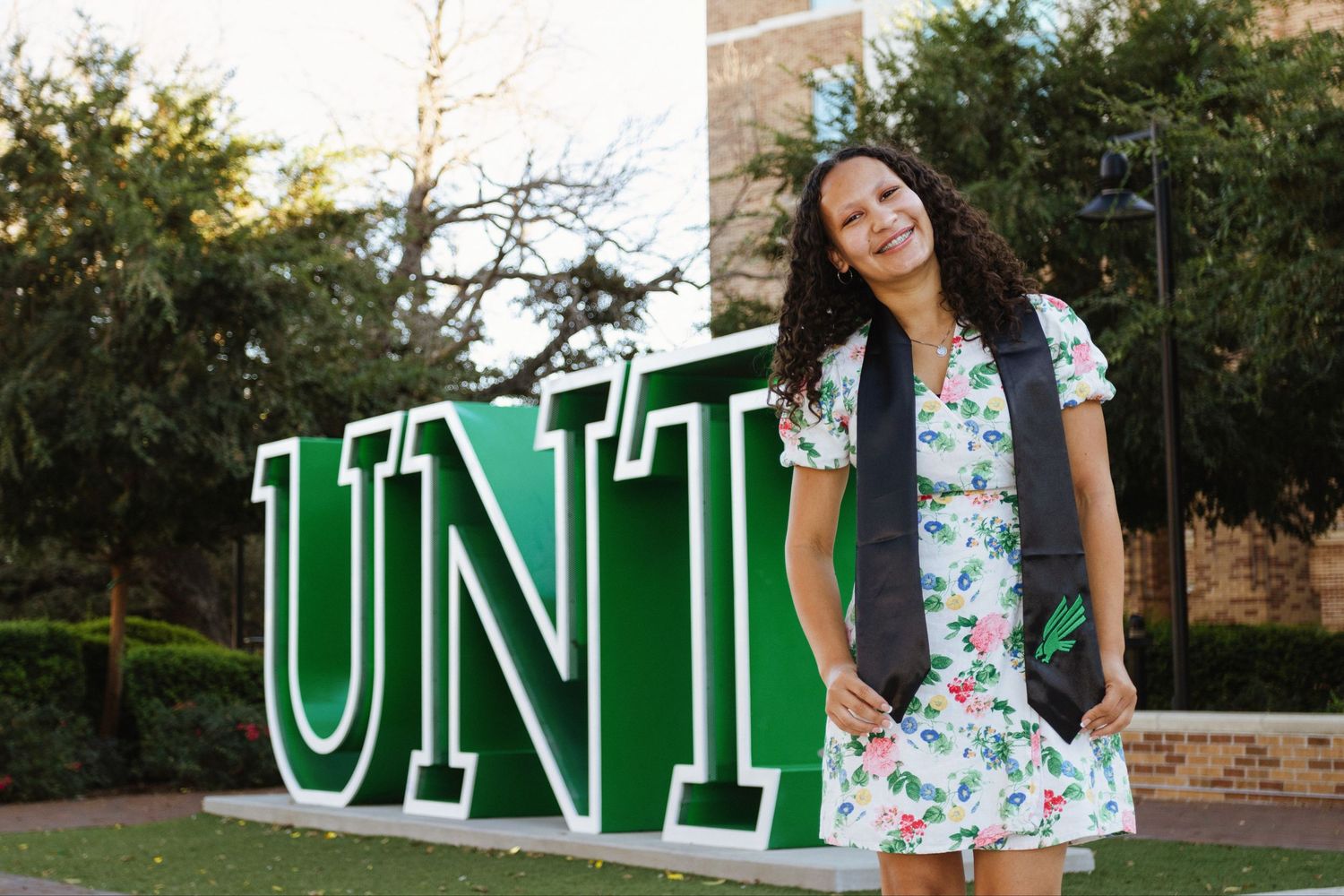 A college student wears her graduation memorabilia on campus.