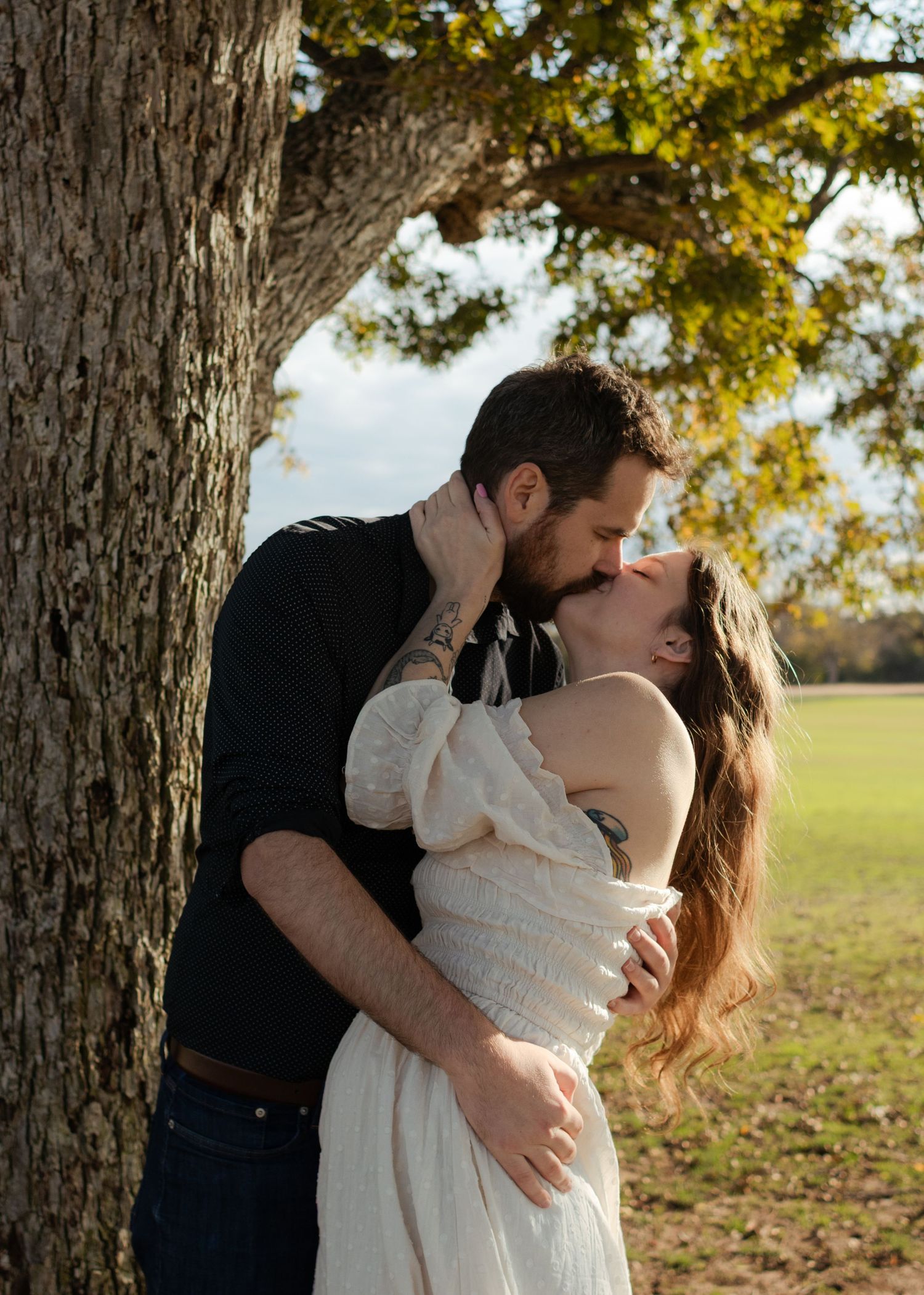 A couple kisses under an old tree near Austin, Texas.