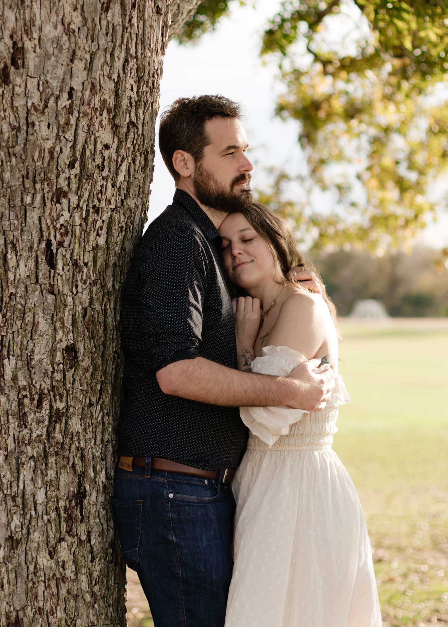 A couple holds each other under an old tree at a park near Austin, Texas.