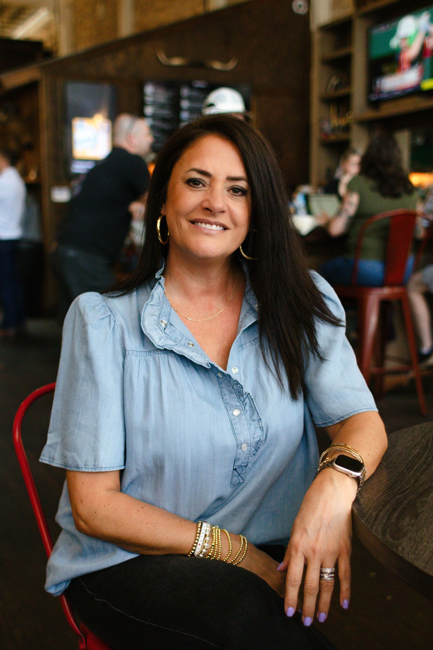 A business owner in Georgetown, Texas, poses for a branding photo while sitiing near the bar.