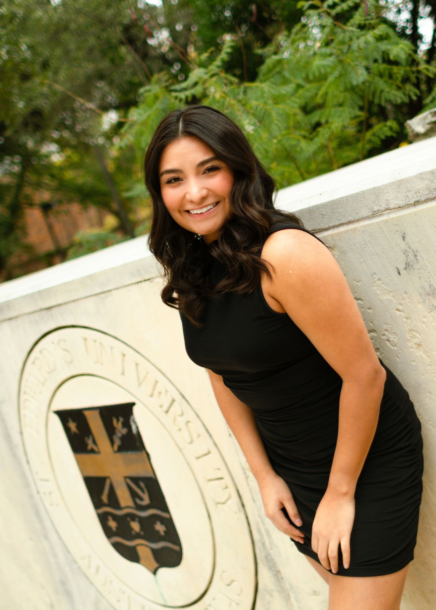 A graduating college senior smiles at St. Edward's University in Austin, Texas, during her senior portraits.