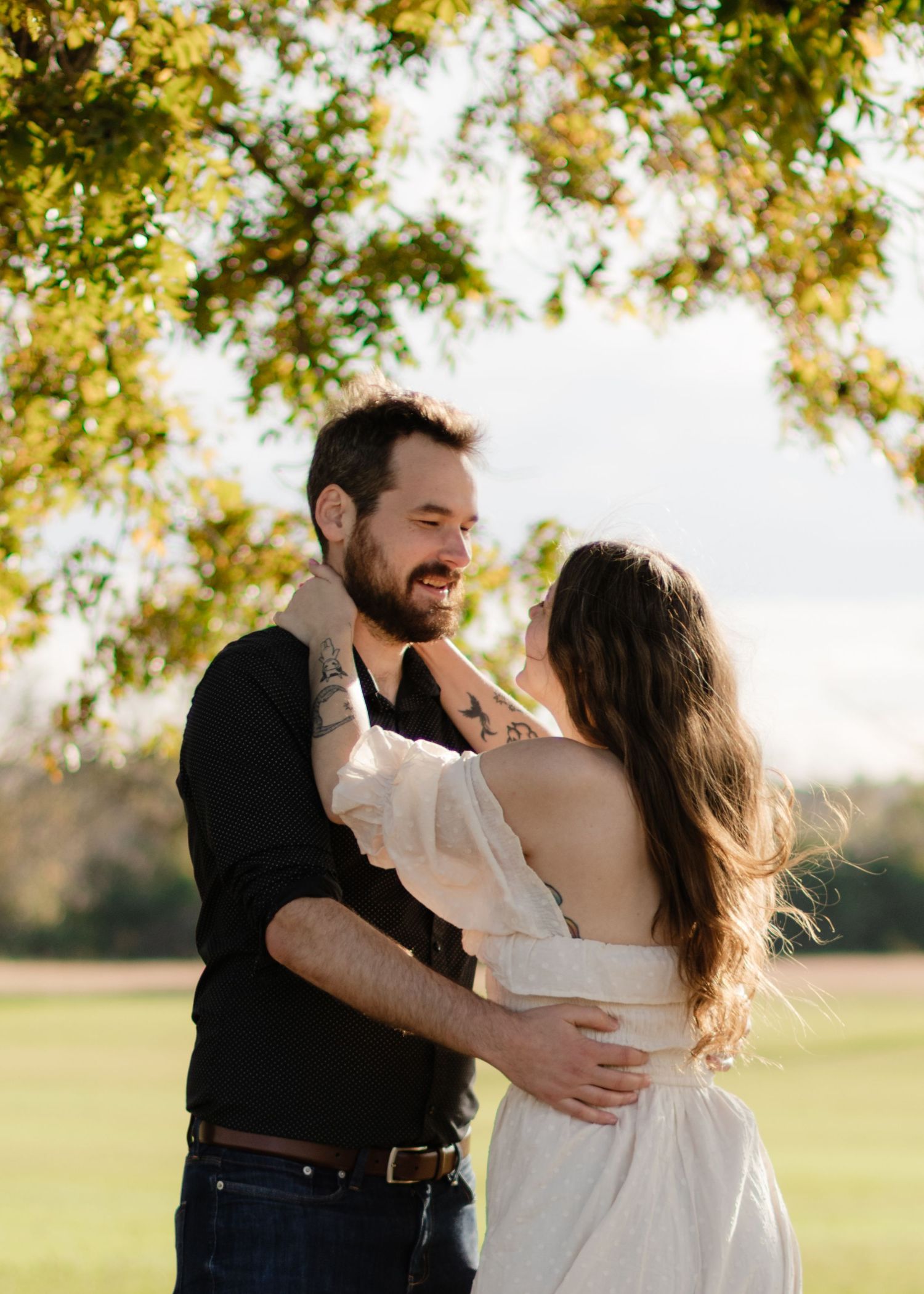 A couple holds each other under an old tree at a park near Austin, Texas.