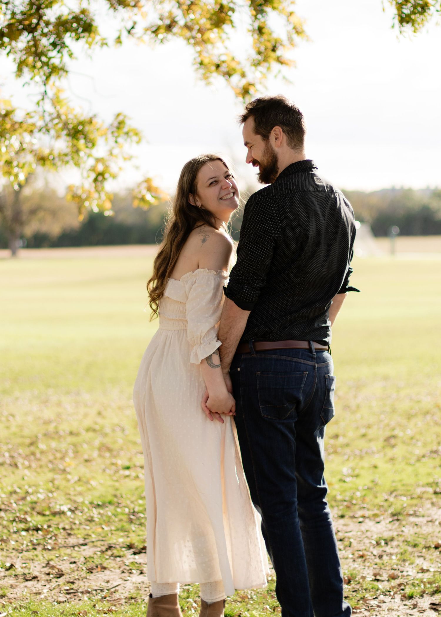 A couple holds hands under an old tree at a park near Austin, Texas.