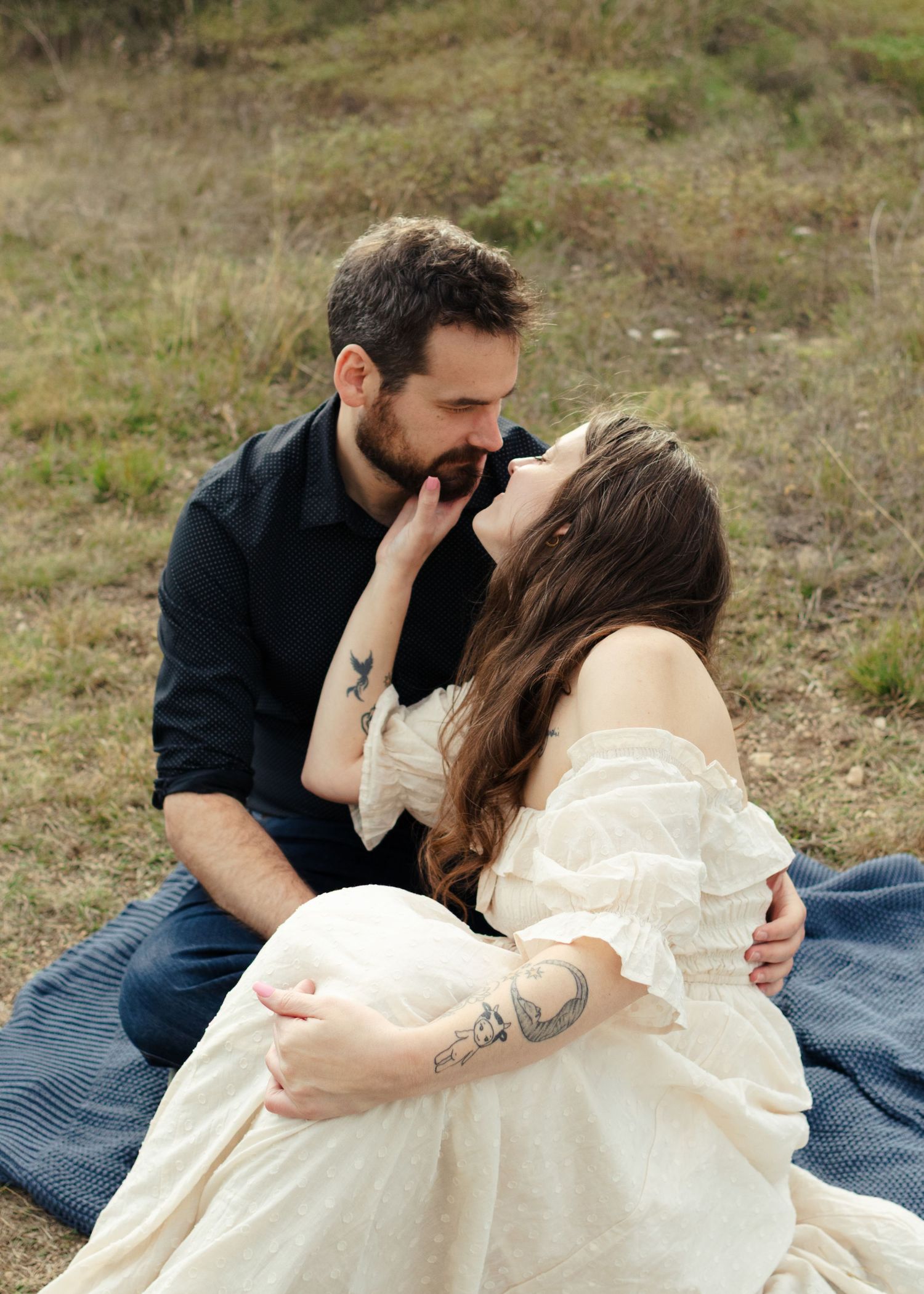 A couple sits on a blanket looking at each other at a park near Austin, Texas.