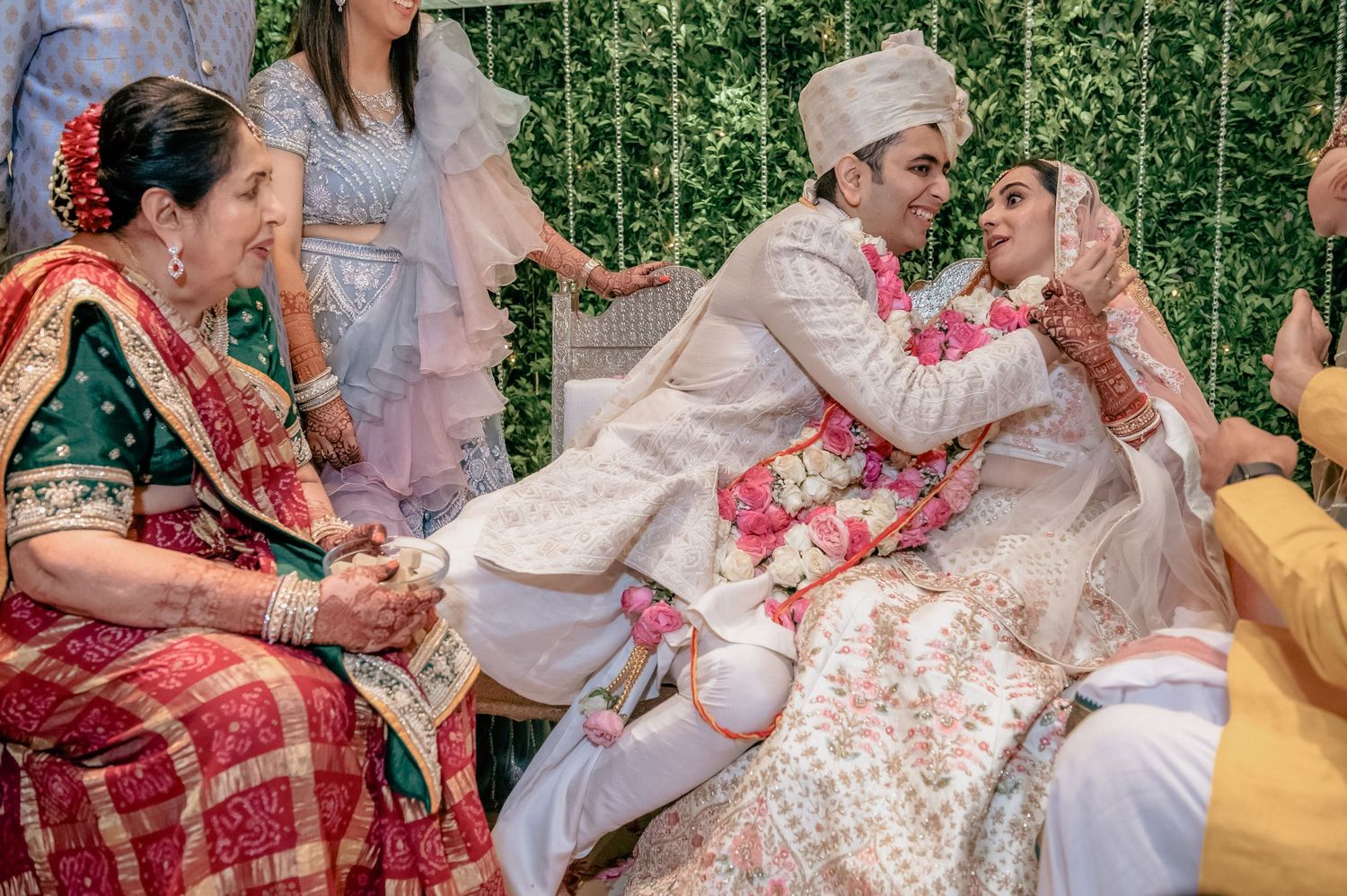 Bride and groom exchange garlands during colorful traditional Indian Hindu wedding ceremony.