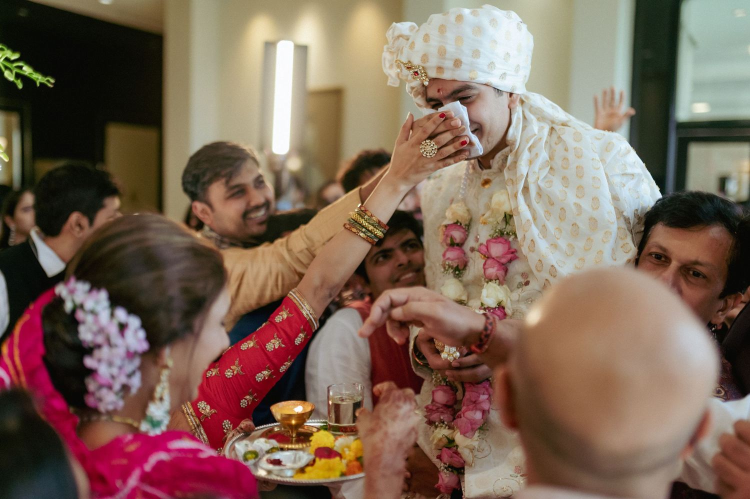 Indian groom receives blessings from family members during traditional wedding rituals.