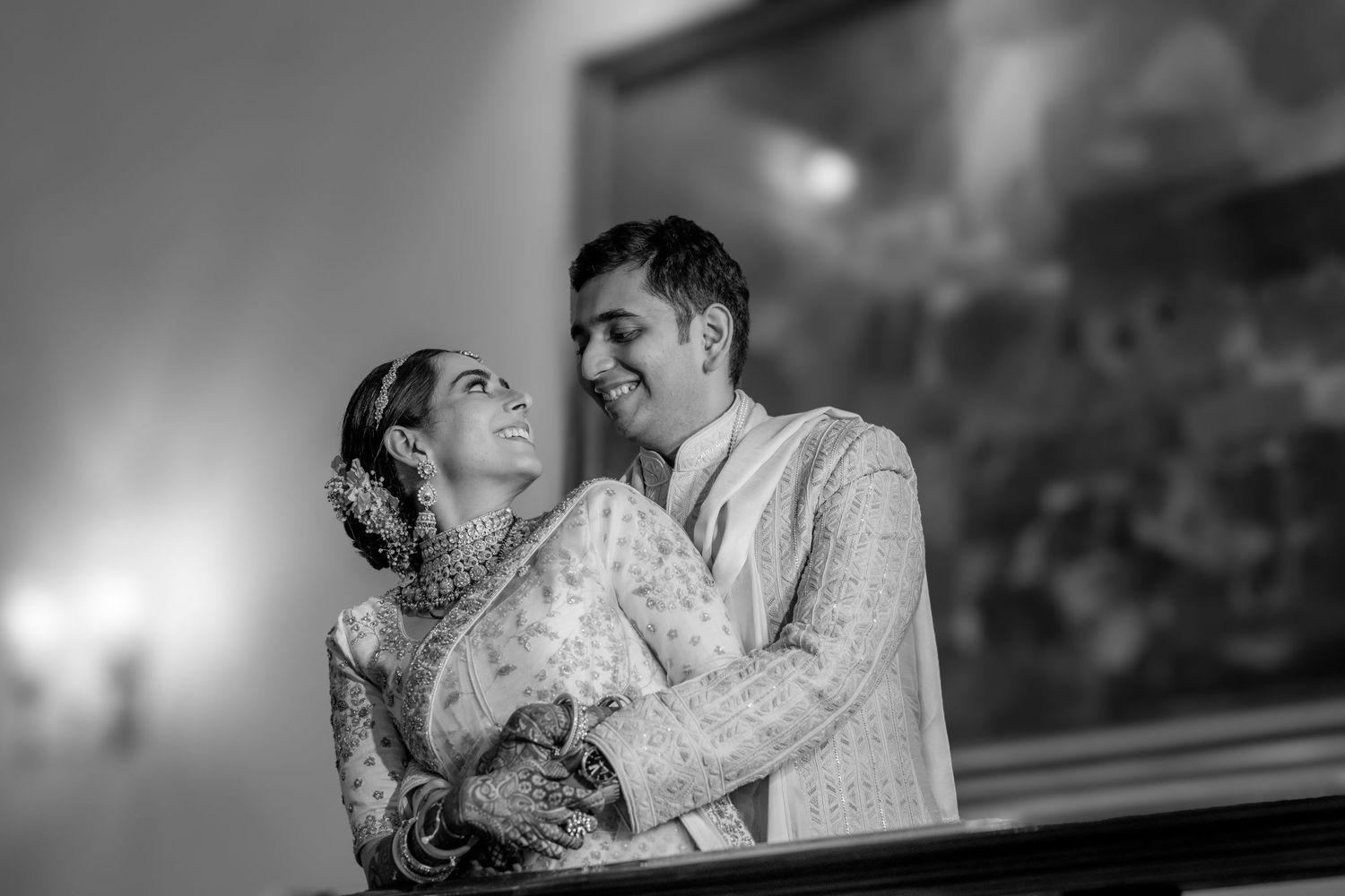 Black and white romantic portrait of Indian bride and groom sharing tender moment at wedding.