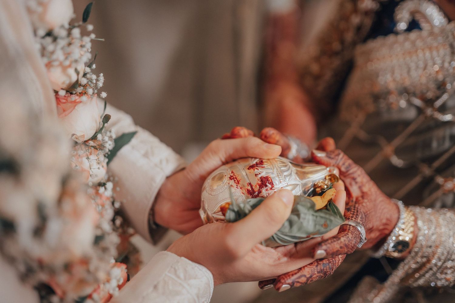 Bride and groom exchange a ceremonial item during a traditional Indian wedding ritual.