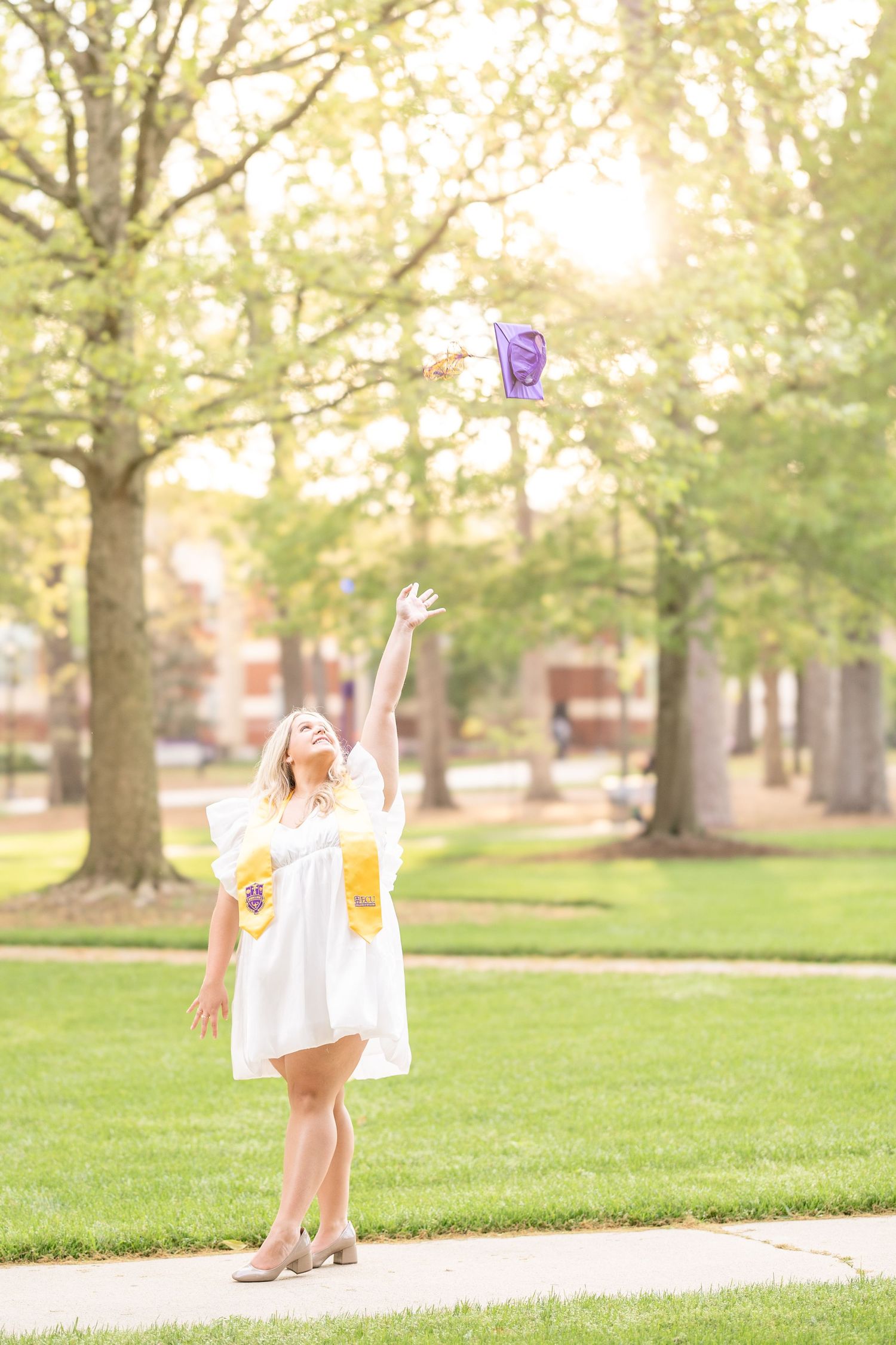 Anna throwing her cap on the beautiful ECU Campus.