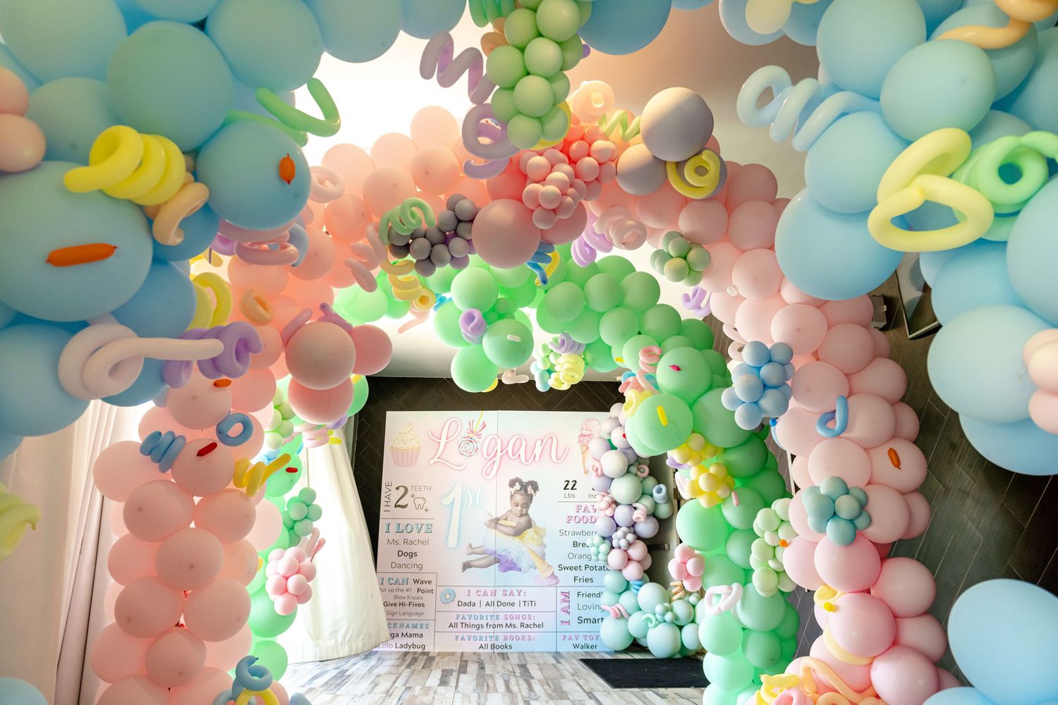 Pastel balloon arch installation with blue, mint green, and peach colors creating an elegant party decoration display.