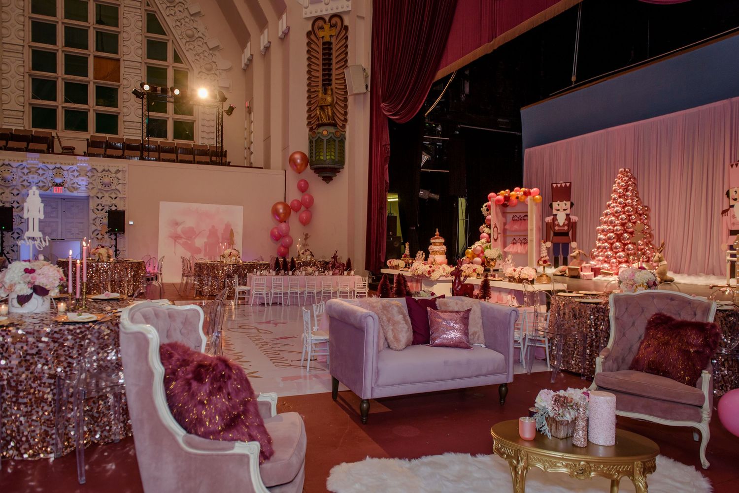 Elegant white and pink wedding reception venue with twinkling lights and decorated Christmas trees in the background.