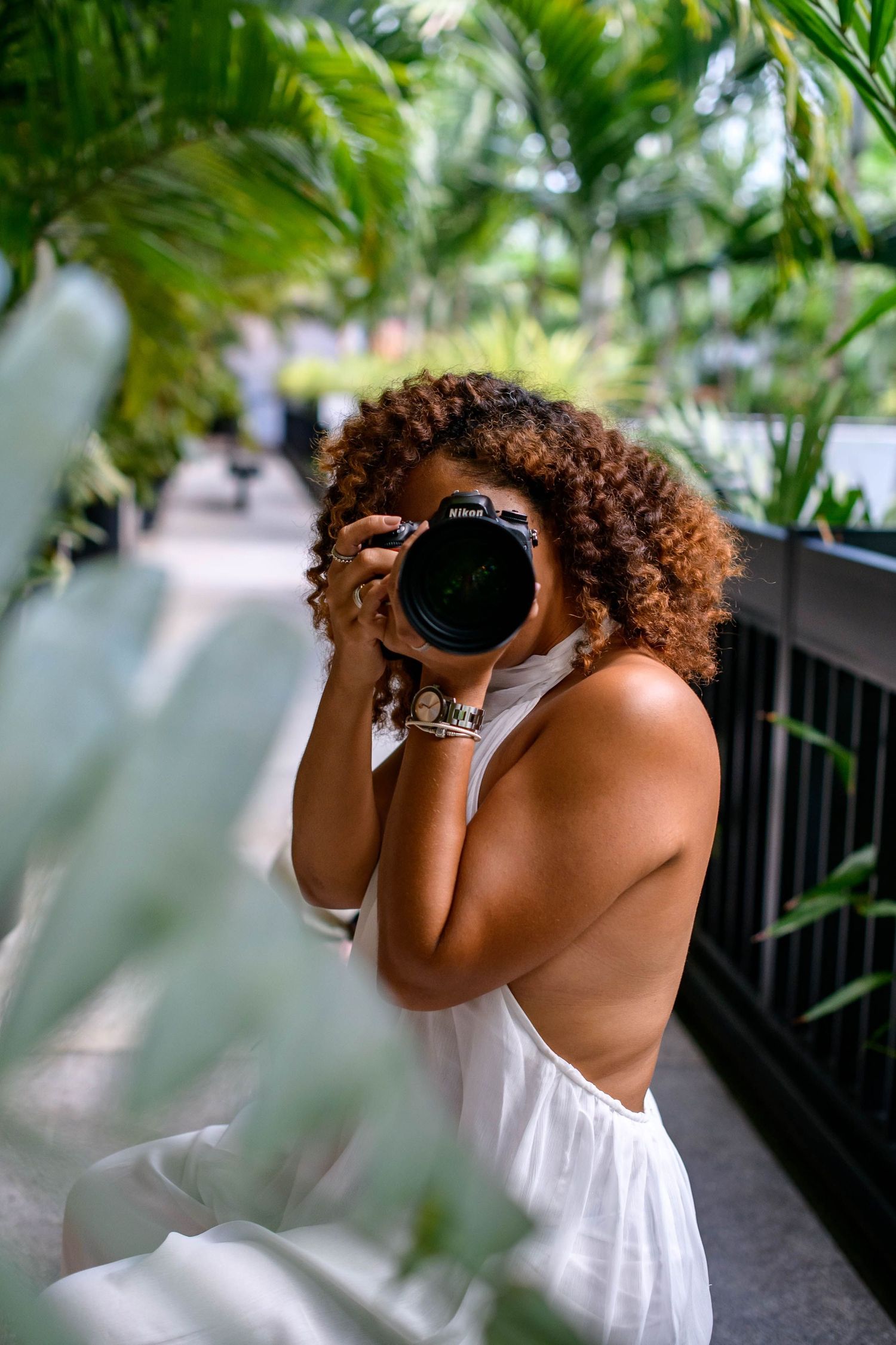 Creative photographer composition with tropical foliage framing the lens.