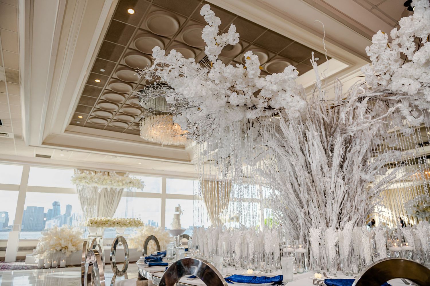 Dramatic white floral ceiling installation in luxury wedding reception venue.