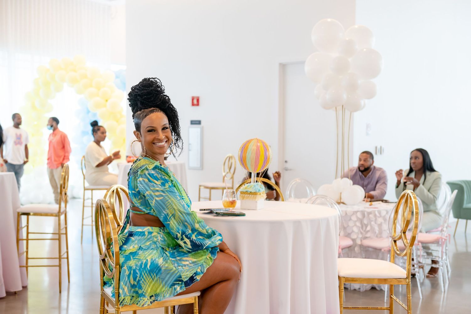 A wedding reception venue decorated in white and gold with elegant table settings and floral arrangements.