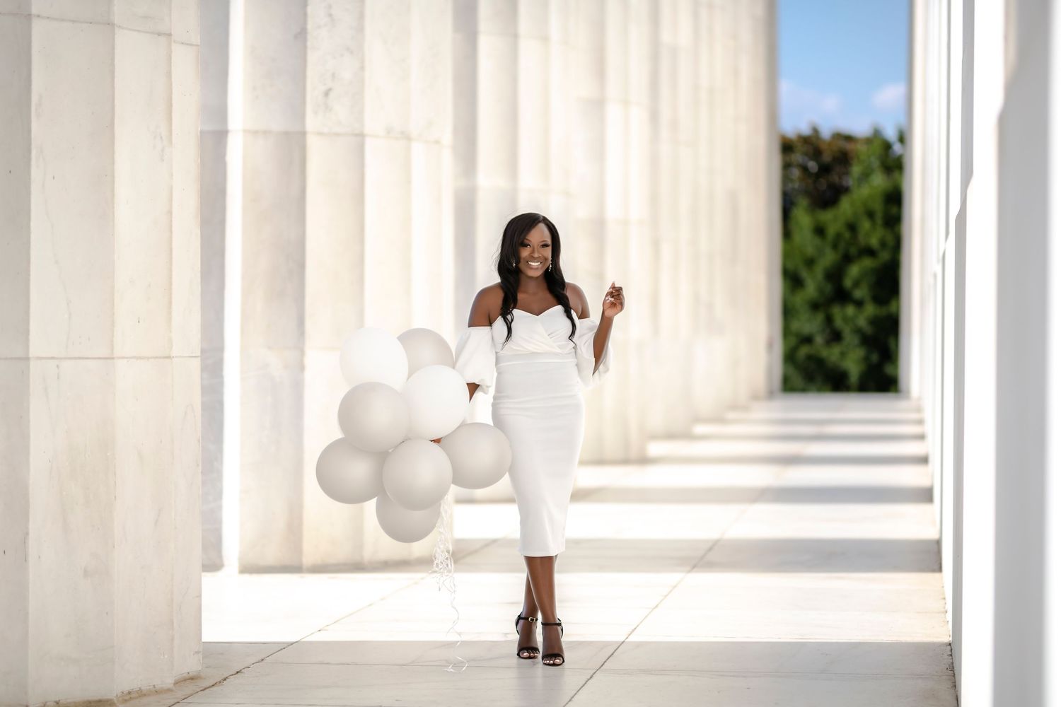 Elegant white dress photoshoot with balloons among classical columns in Washington, DC.
