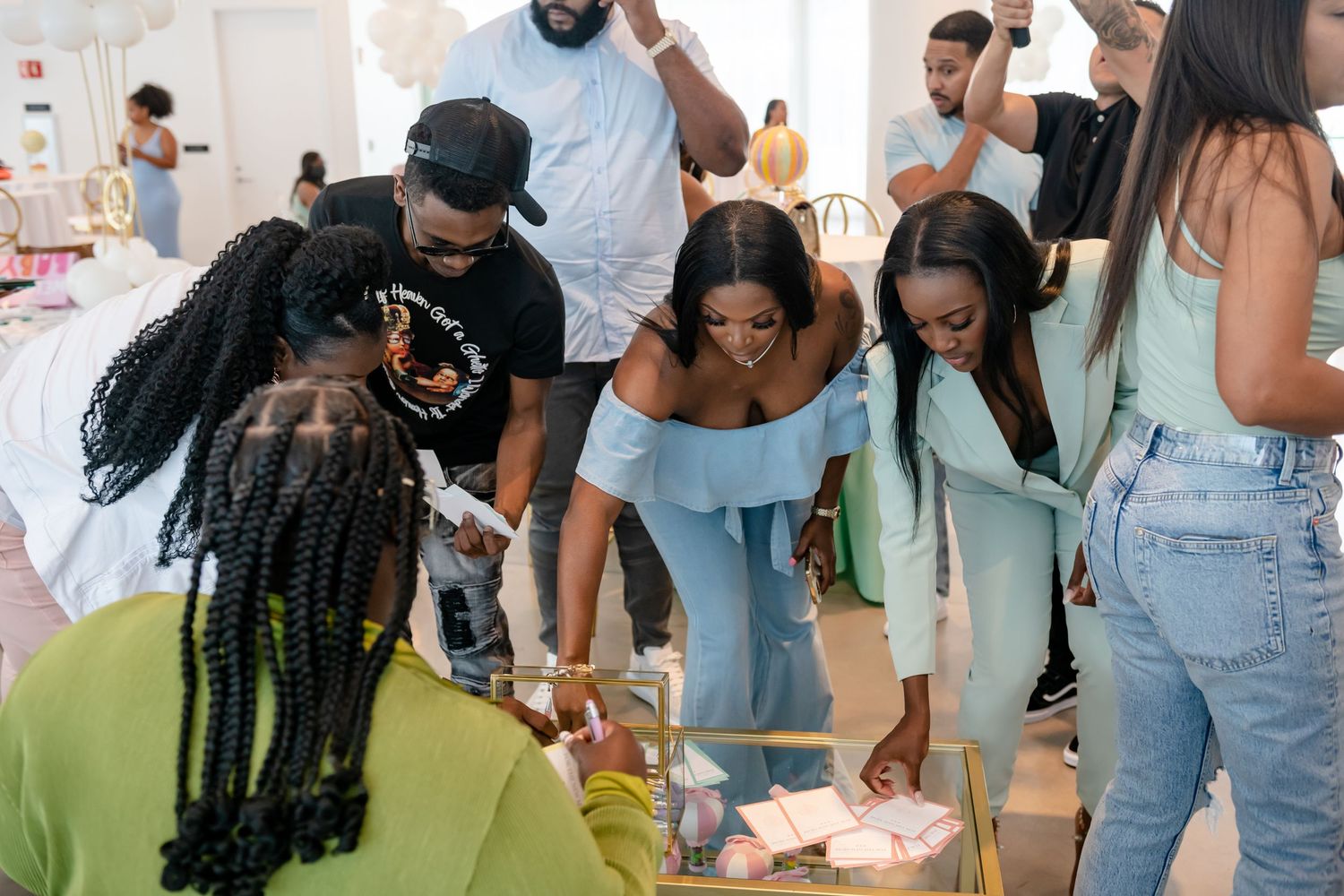 A group of people gathered at a social event wearing casual summer outfits and enjoying themselves.