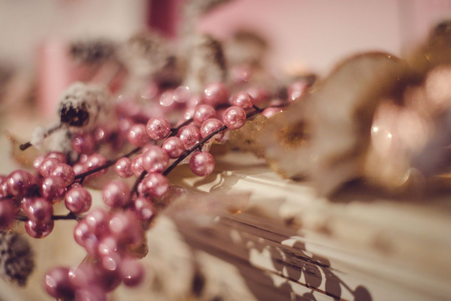 Pink berries and floral decorations adorn a winter wedding setting with soft bokeh lighting effects.