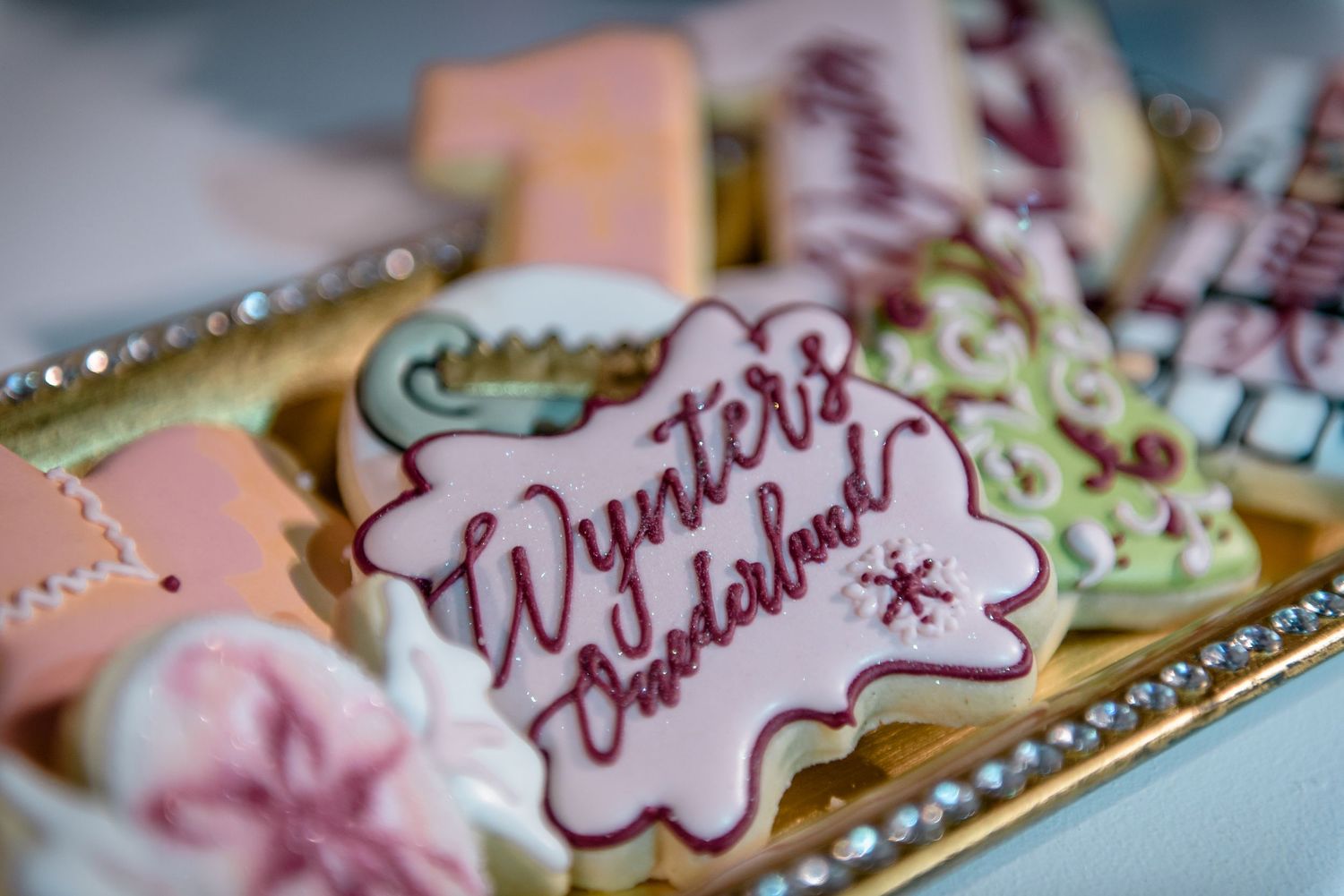 Close-up shot of a decorated cookie with 'Winter Wonderland' text in burgundy frosting.