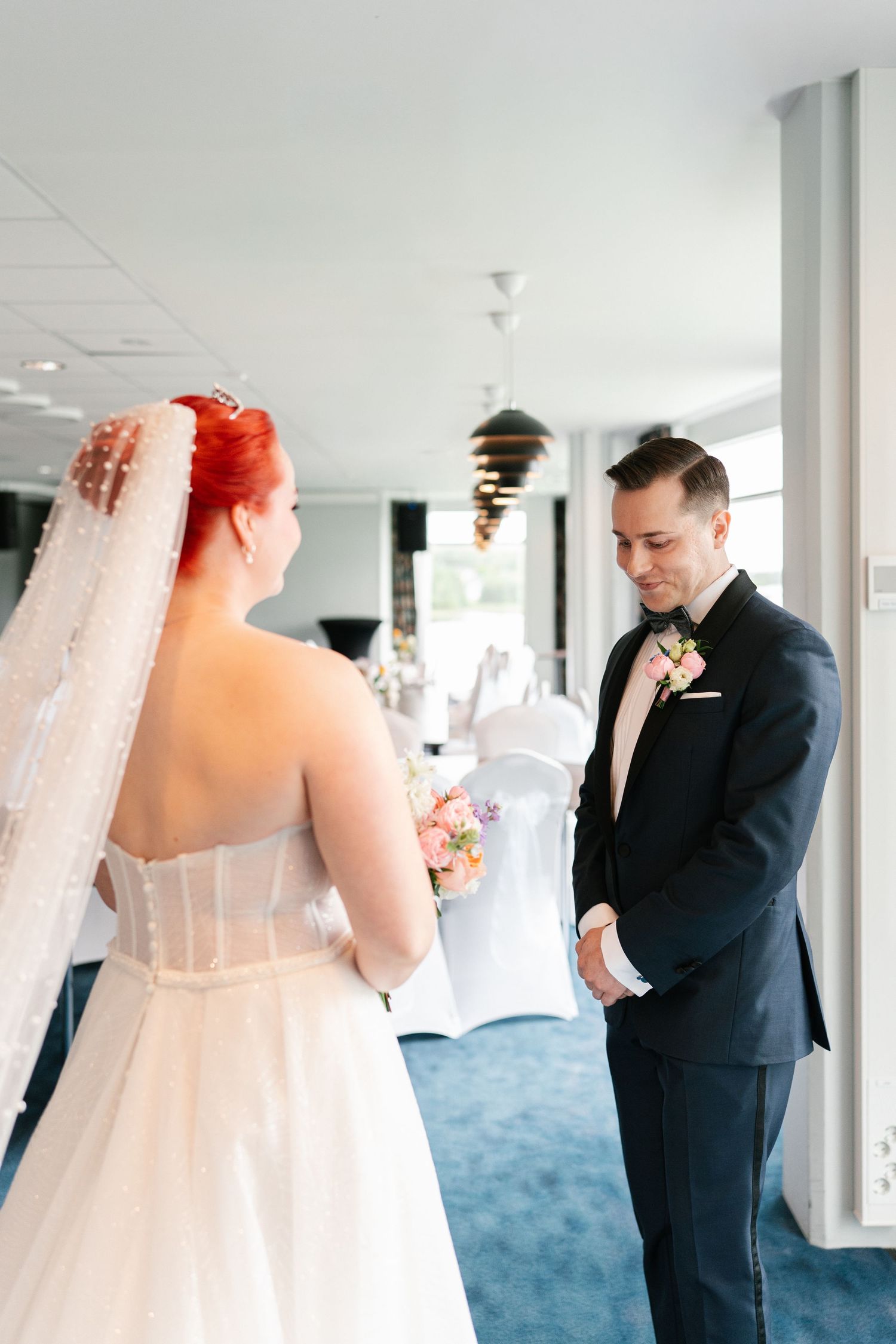 First look wedding photos showing anticipation between couple in elegant venue.