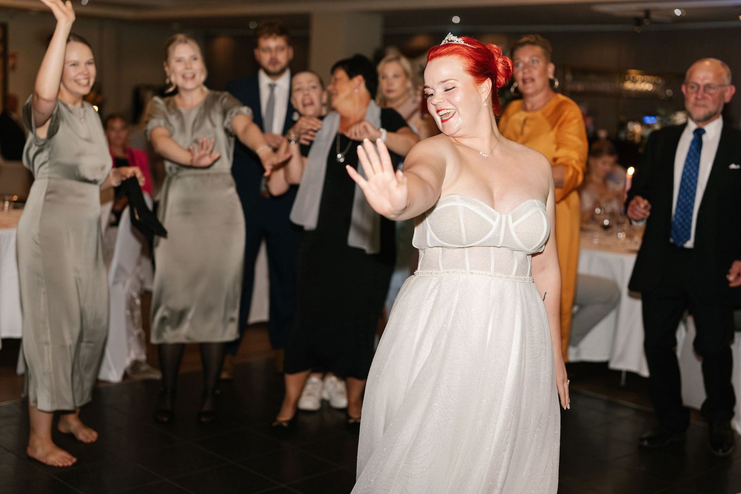 Wedding party members dance and celebrate during the reception.