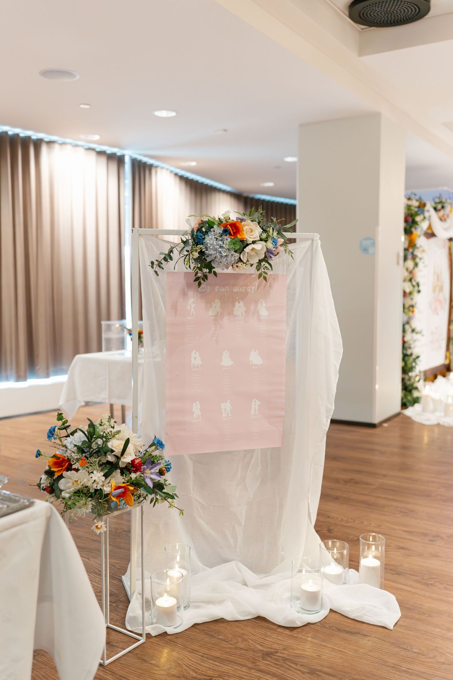 White decorative screens with floral arrangements create an elegant wedding ceremony backdrop in a modern venue.