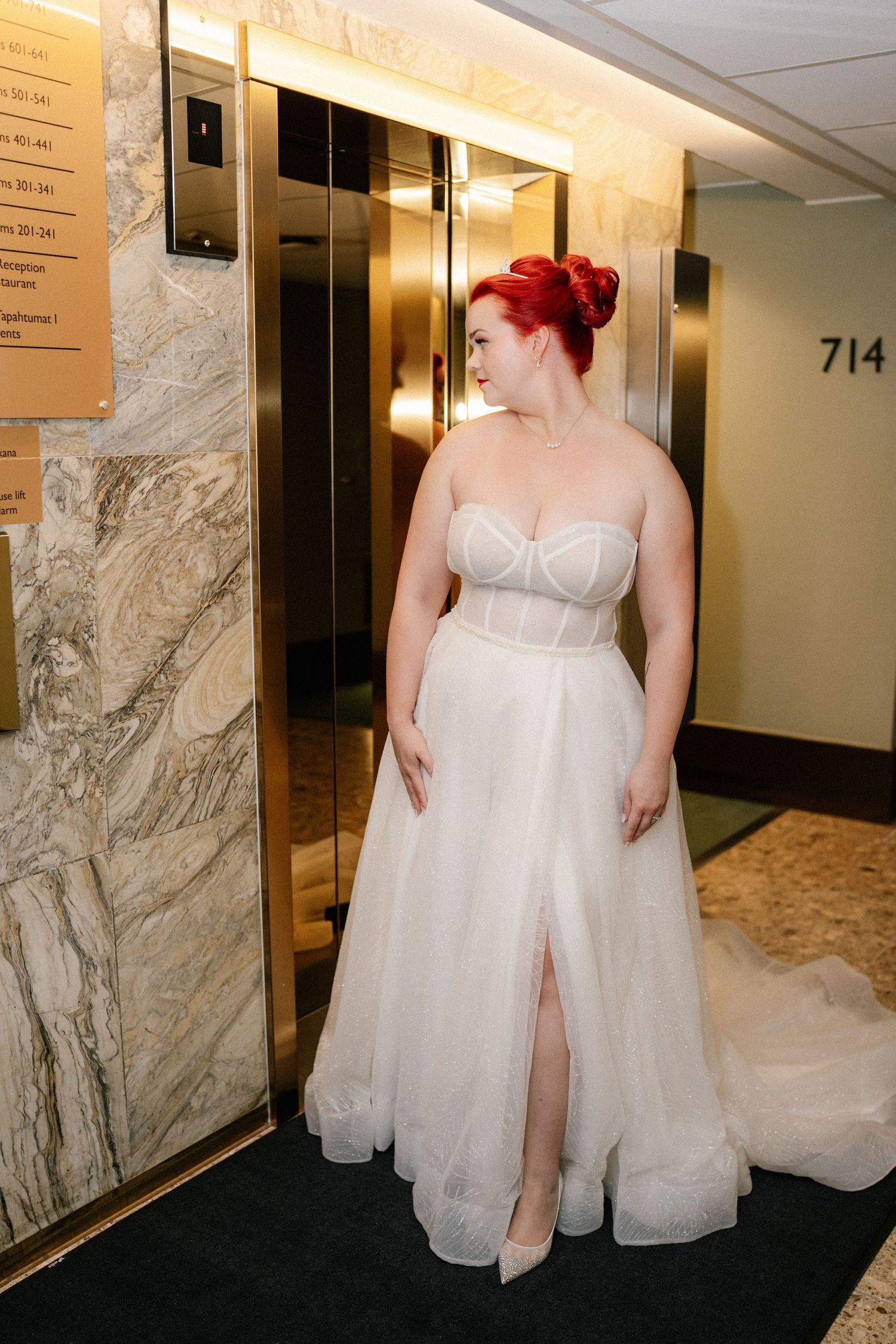 Wedding dress detail shots in hotel hallway with marble walls.