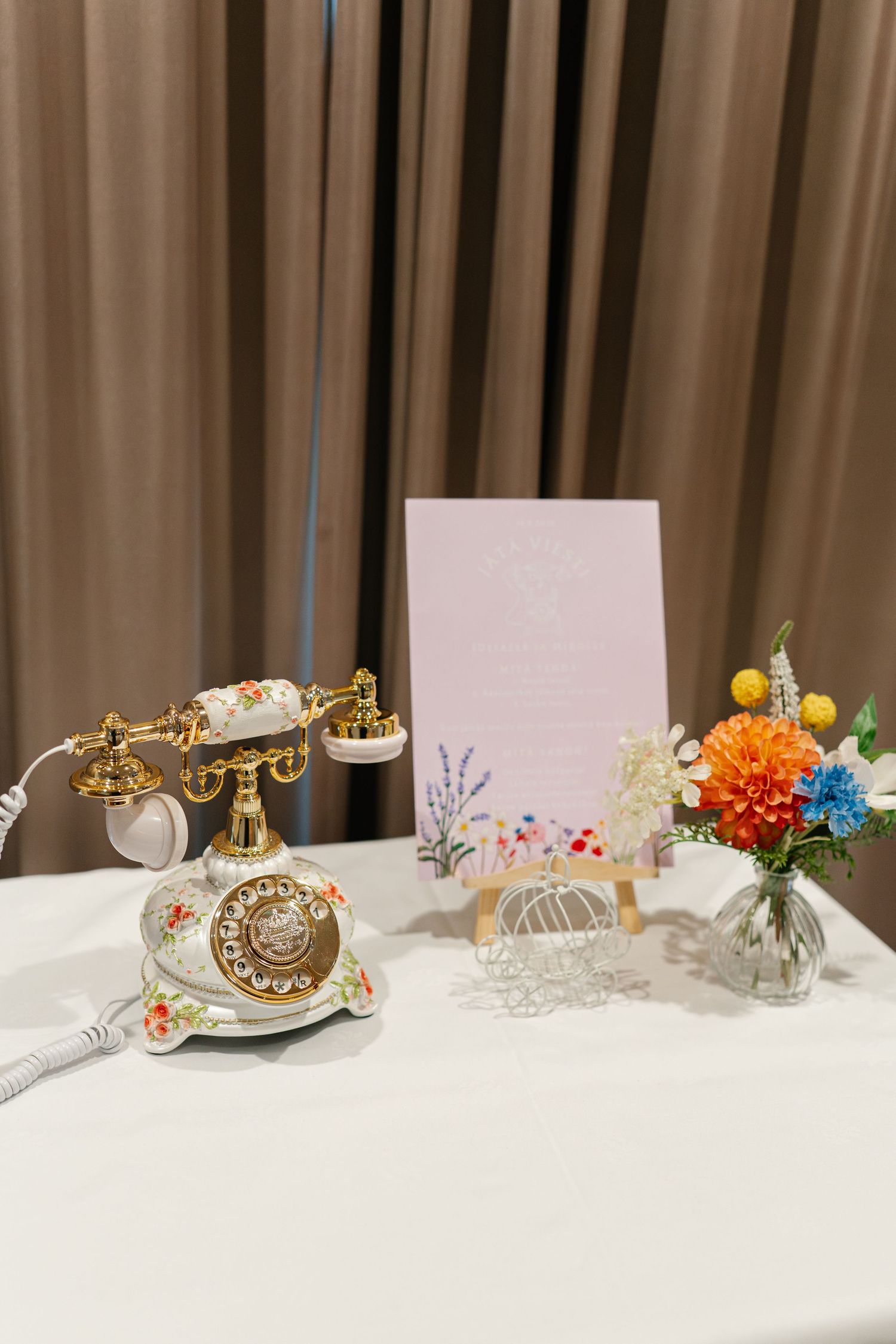 Close-up of wedding table decorations featuring vintage-style ornaments and colorful floral arrangements.