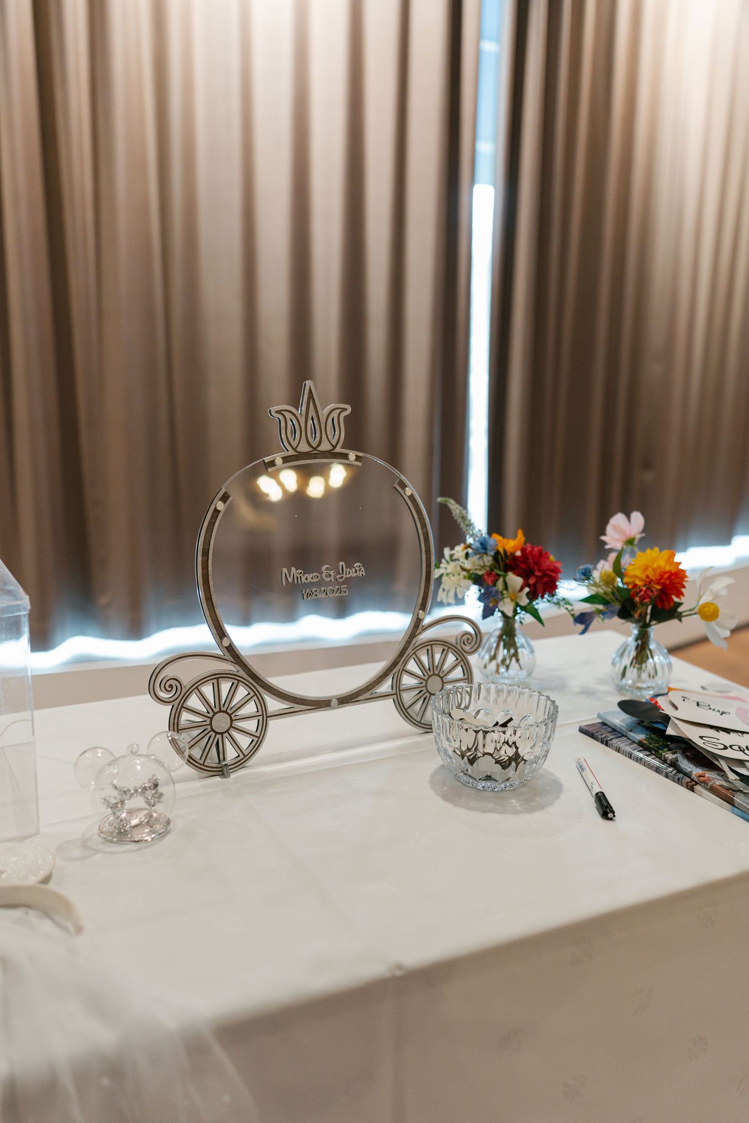 Decorative carriage-themed table ornaments and floral arrangements on white tablecloths.